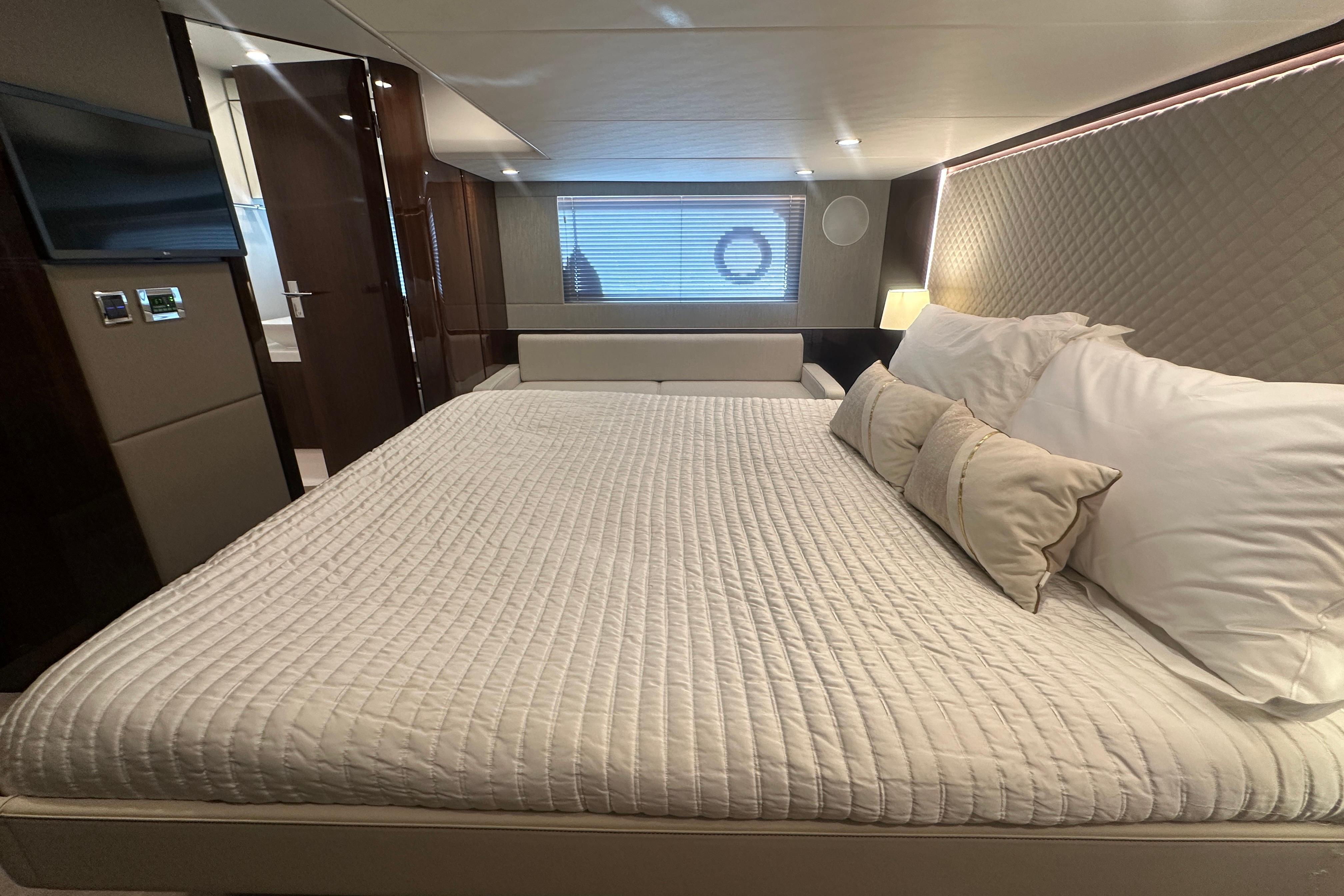 Luxurious bedroom interior of 2024 Fairline Squadron 50 yacht, featuring elegant bedding and modern design.