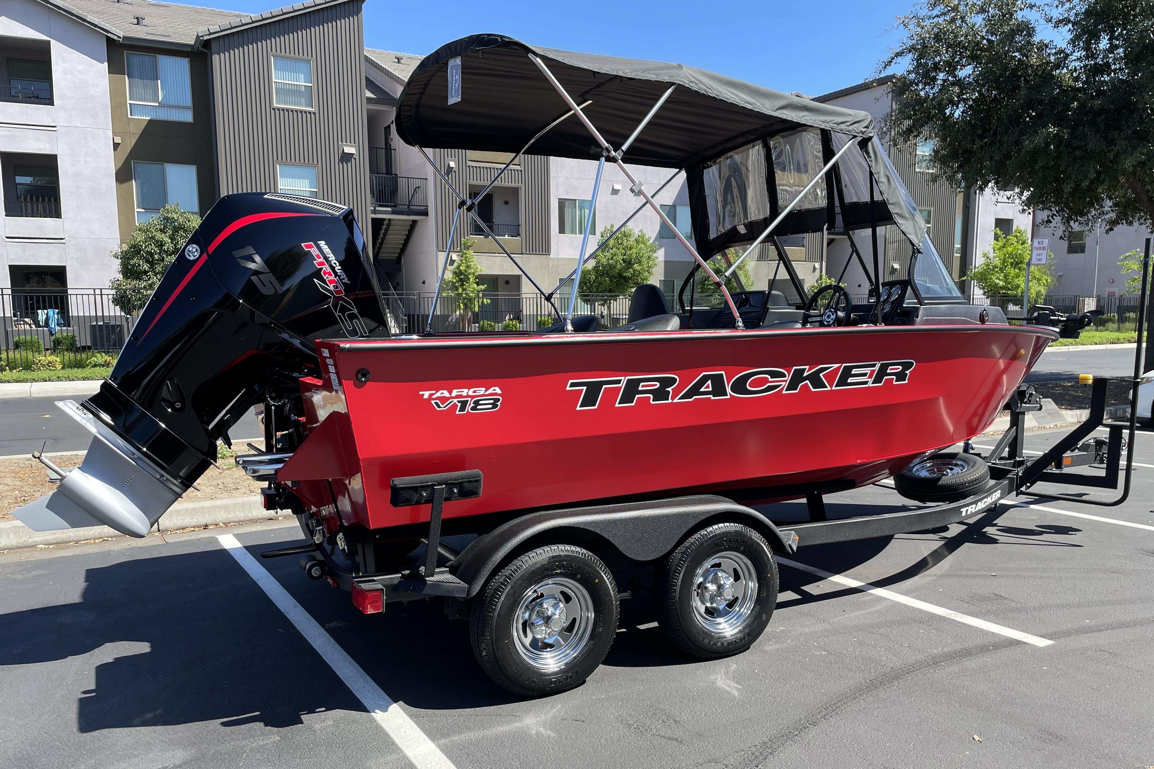 2026 Tracker Targa V-18 WT boat on trailer, parked in urban setting.
