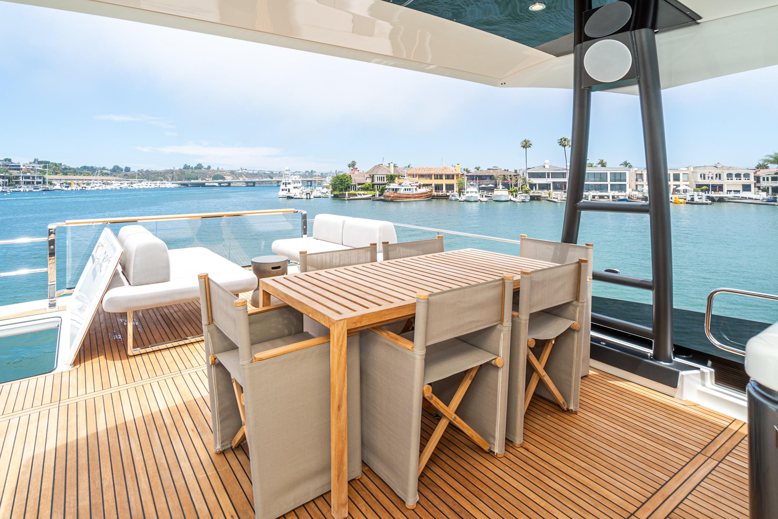 Luxurious 2024 Prestige X60 yacht deck with elegant seating and scenic waterfront view.