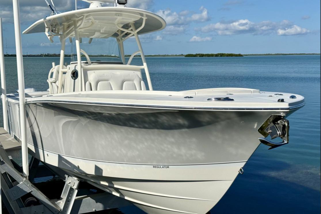 2019 Regulator 31 boat docked by serene blue waters under a clear sky.