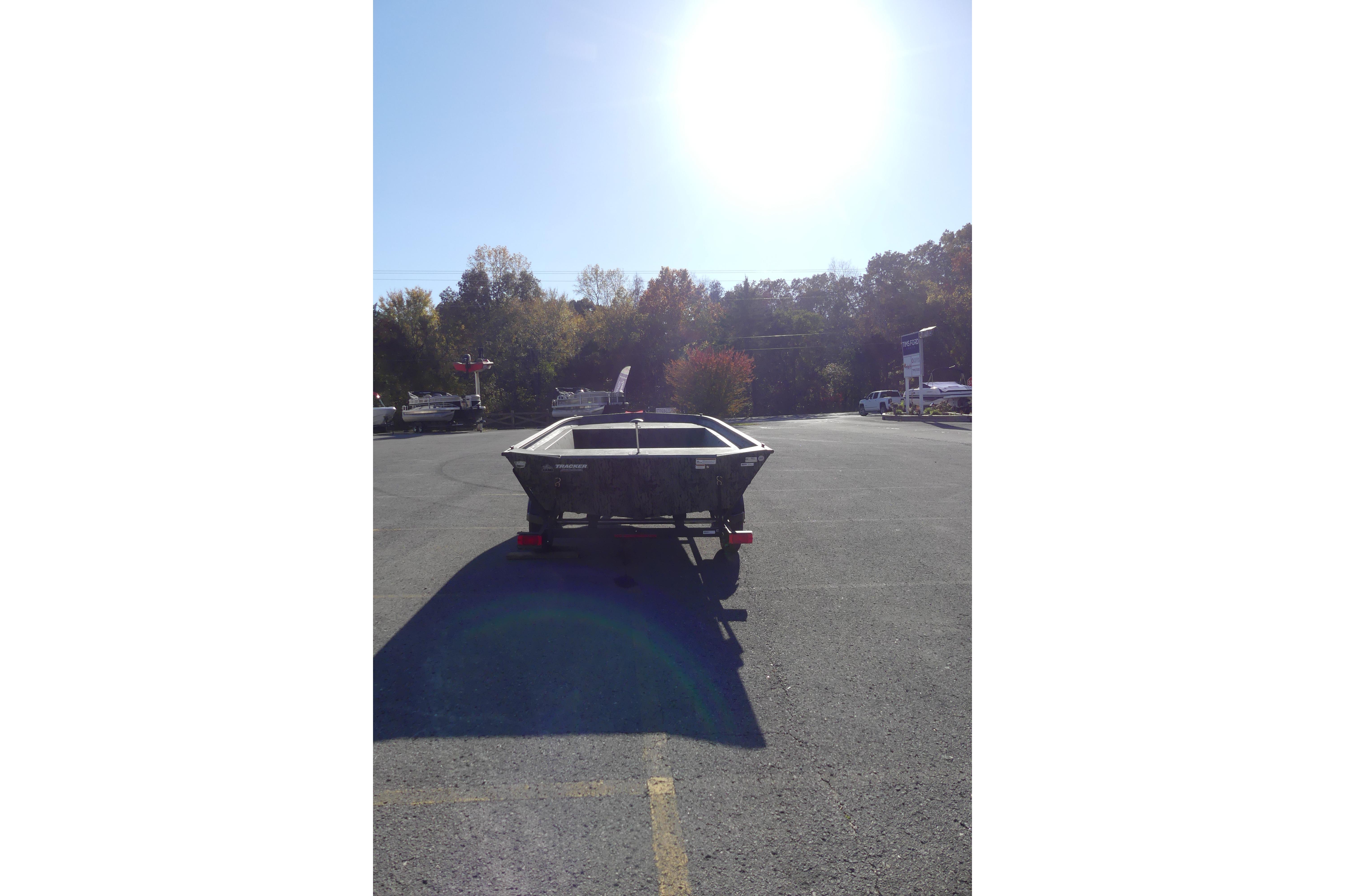2026 Tracker Grizzly 1860 Utility boat in a sunny parking lot.