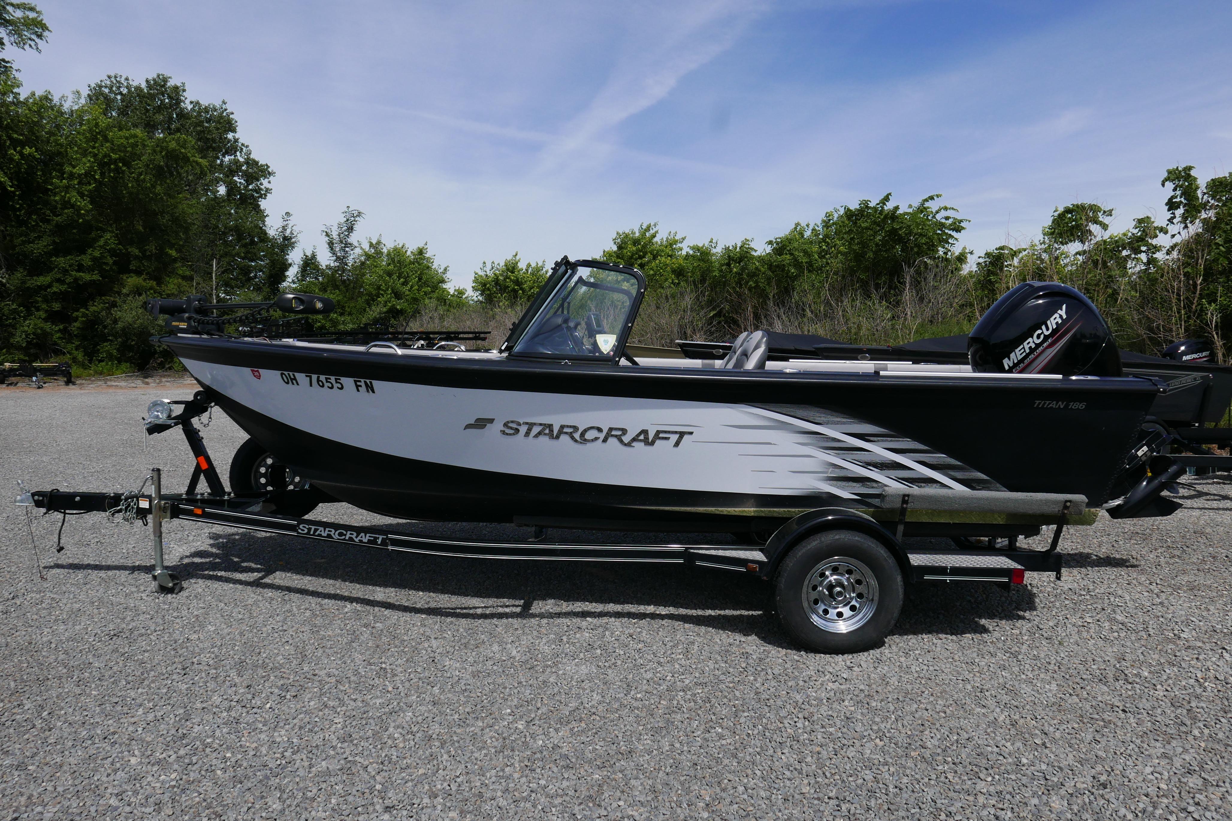 2016 Starcraft Titan 186 boat on trailer, parked outdoors with trees in background.