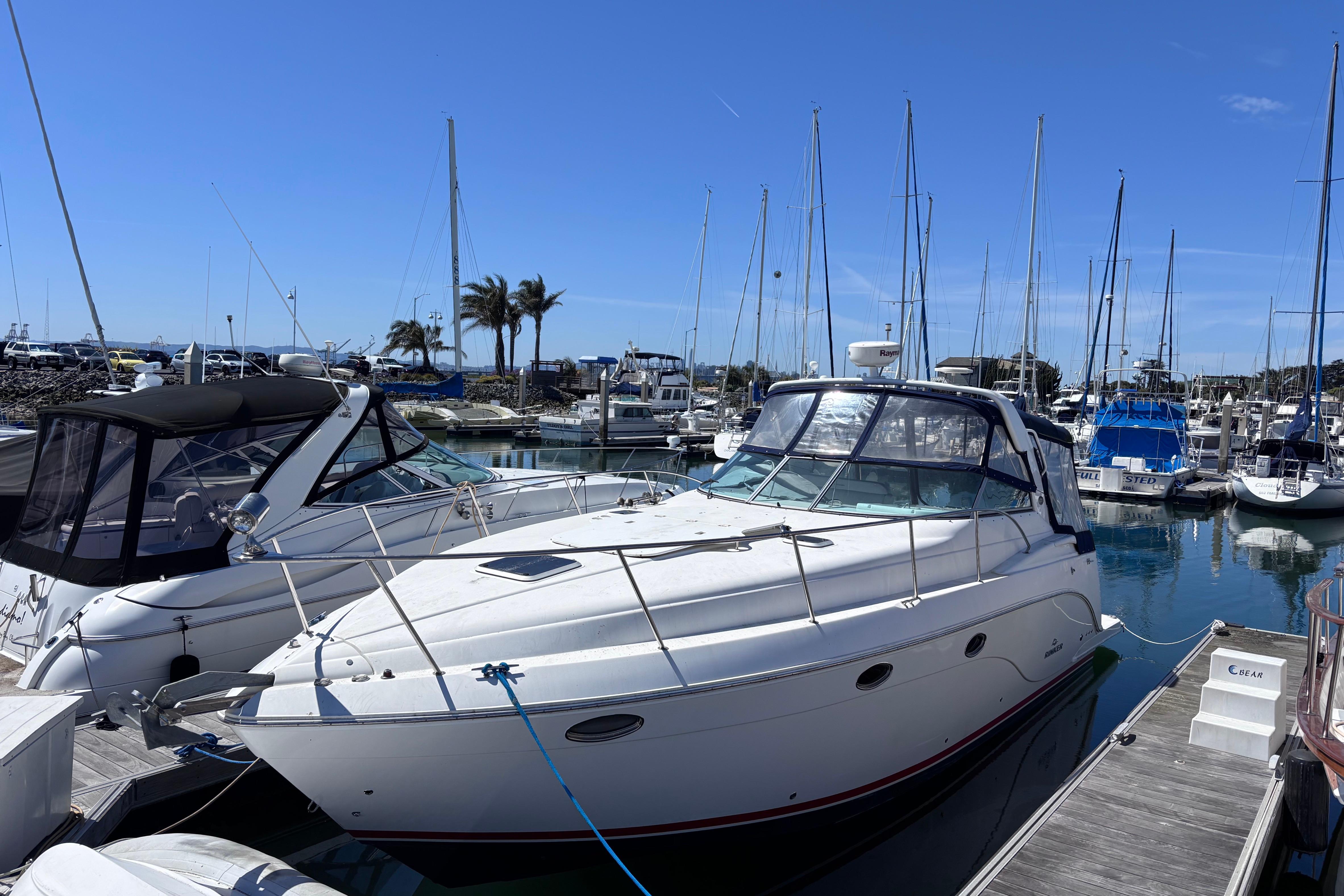 2007 Rinker EX 370 boat docked in a marina with clear blue skies.