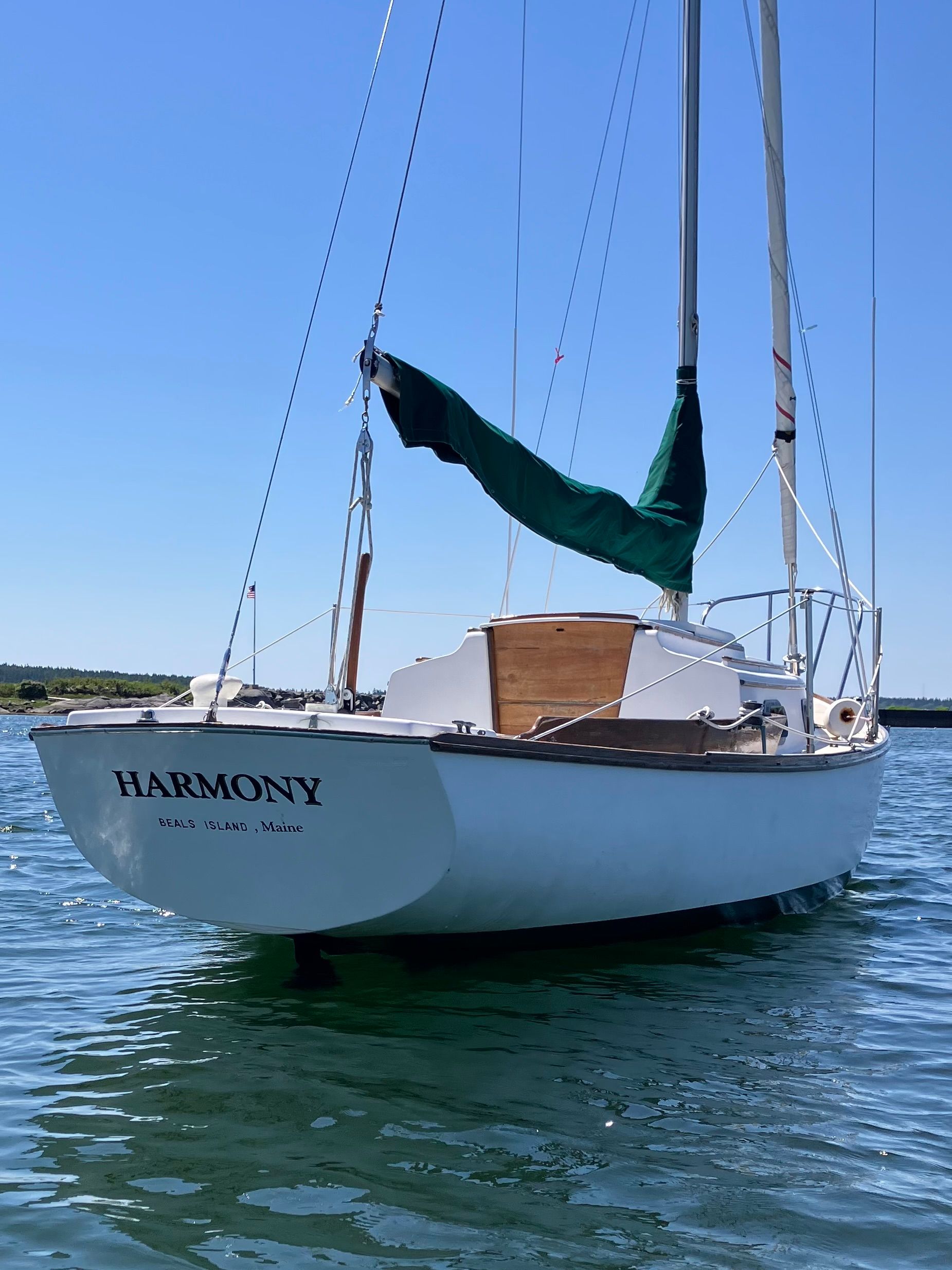 A 1982 Cape Dory 25 sailboat named "Harmony" floats on the water.