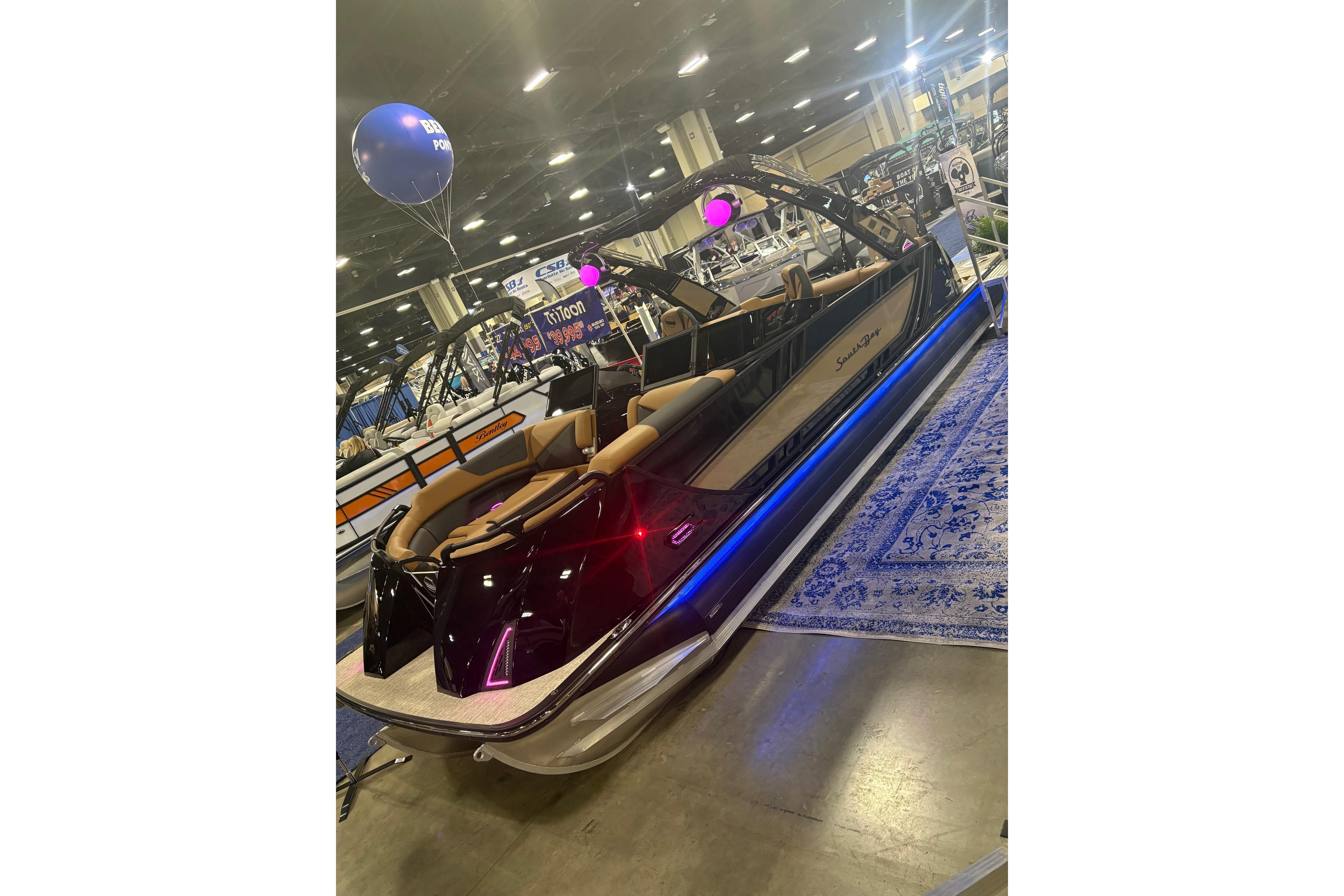 2026 South Bay Sport RS9 DC pontoon boat displayed indoors with vibrant lighting.