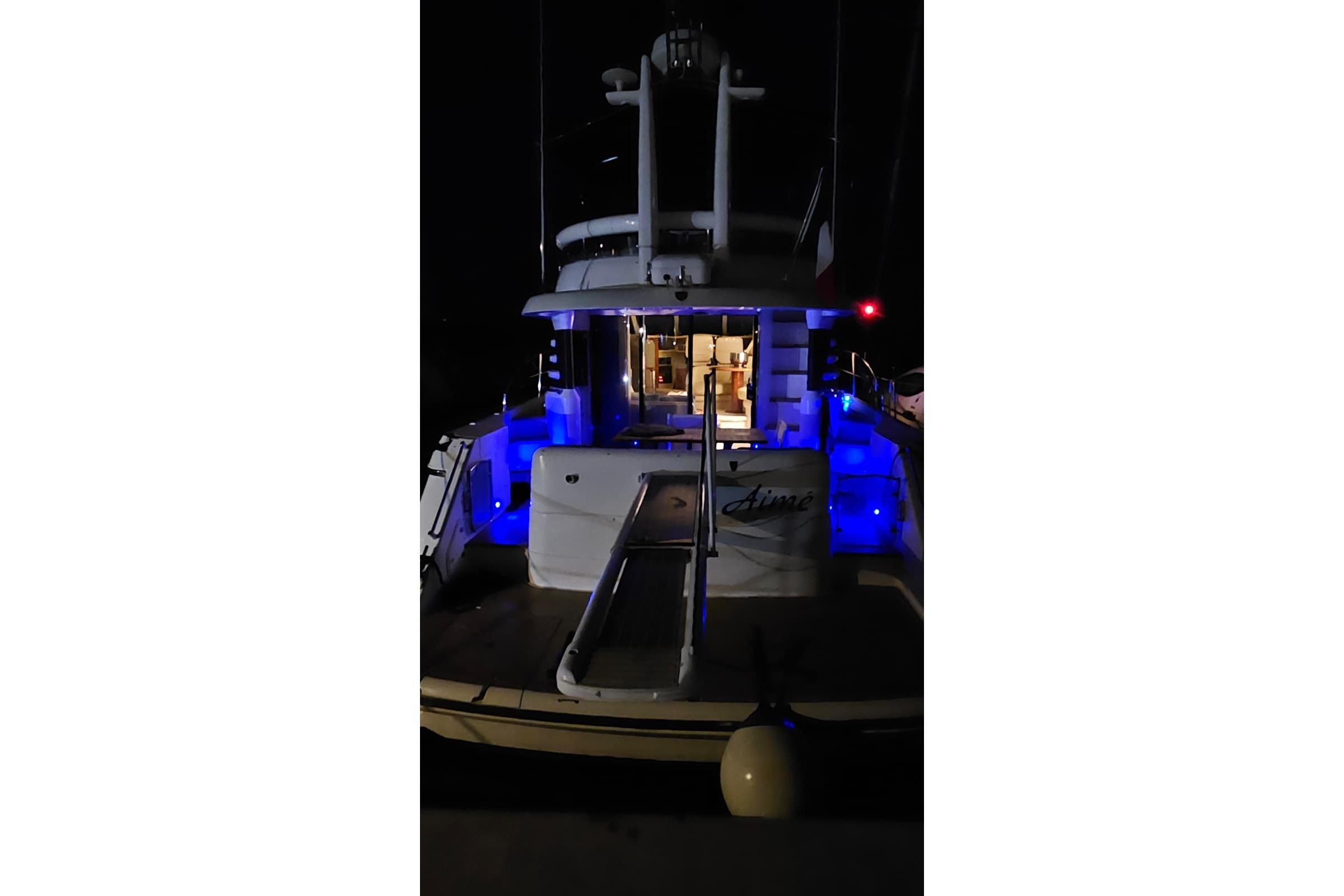 2001 Fairline Squadron 52 yacht illuminated at night with blue lights.