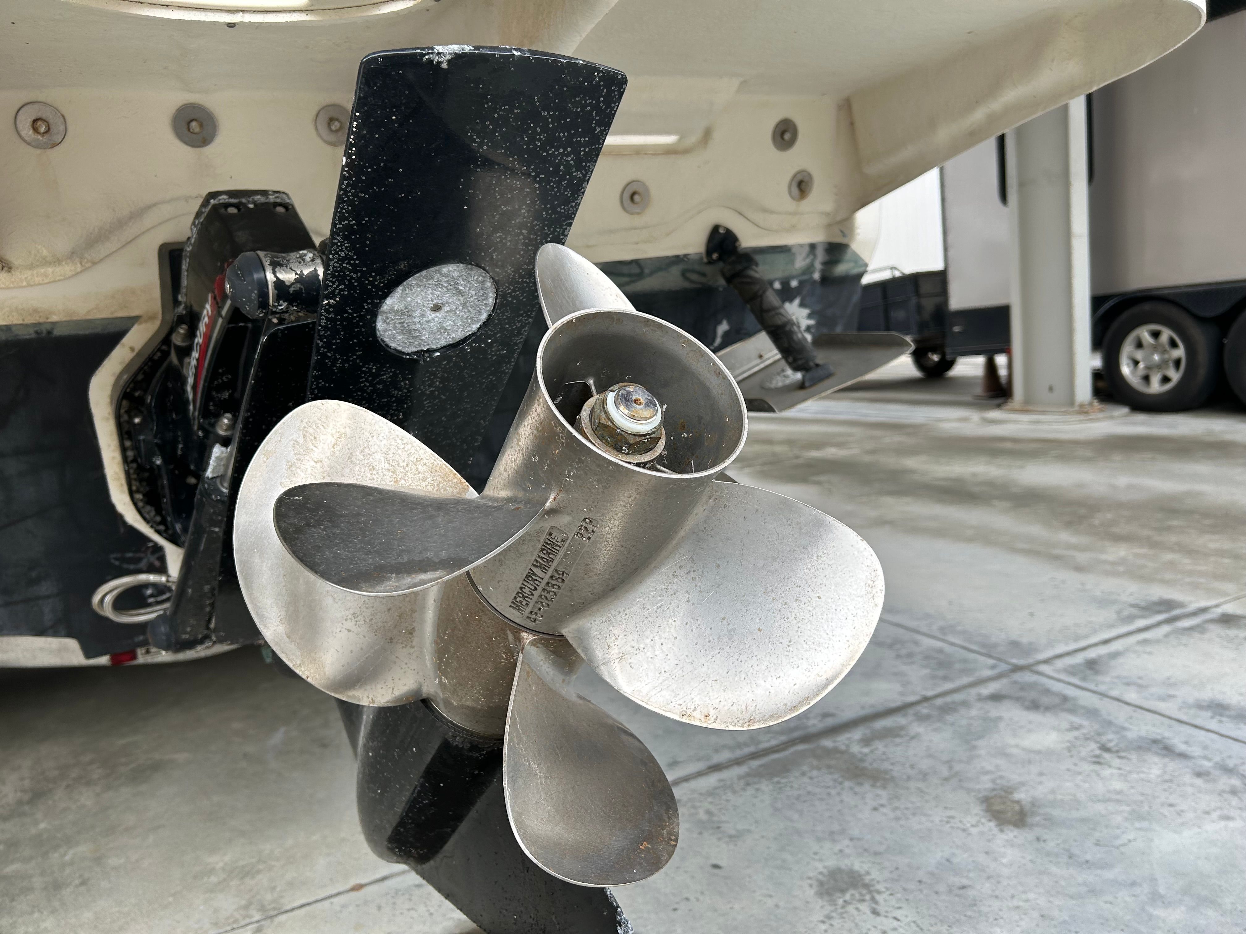 Close-up of a 2003 Sea Ray 240 Sundancer boat propeller in a marina setting.