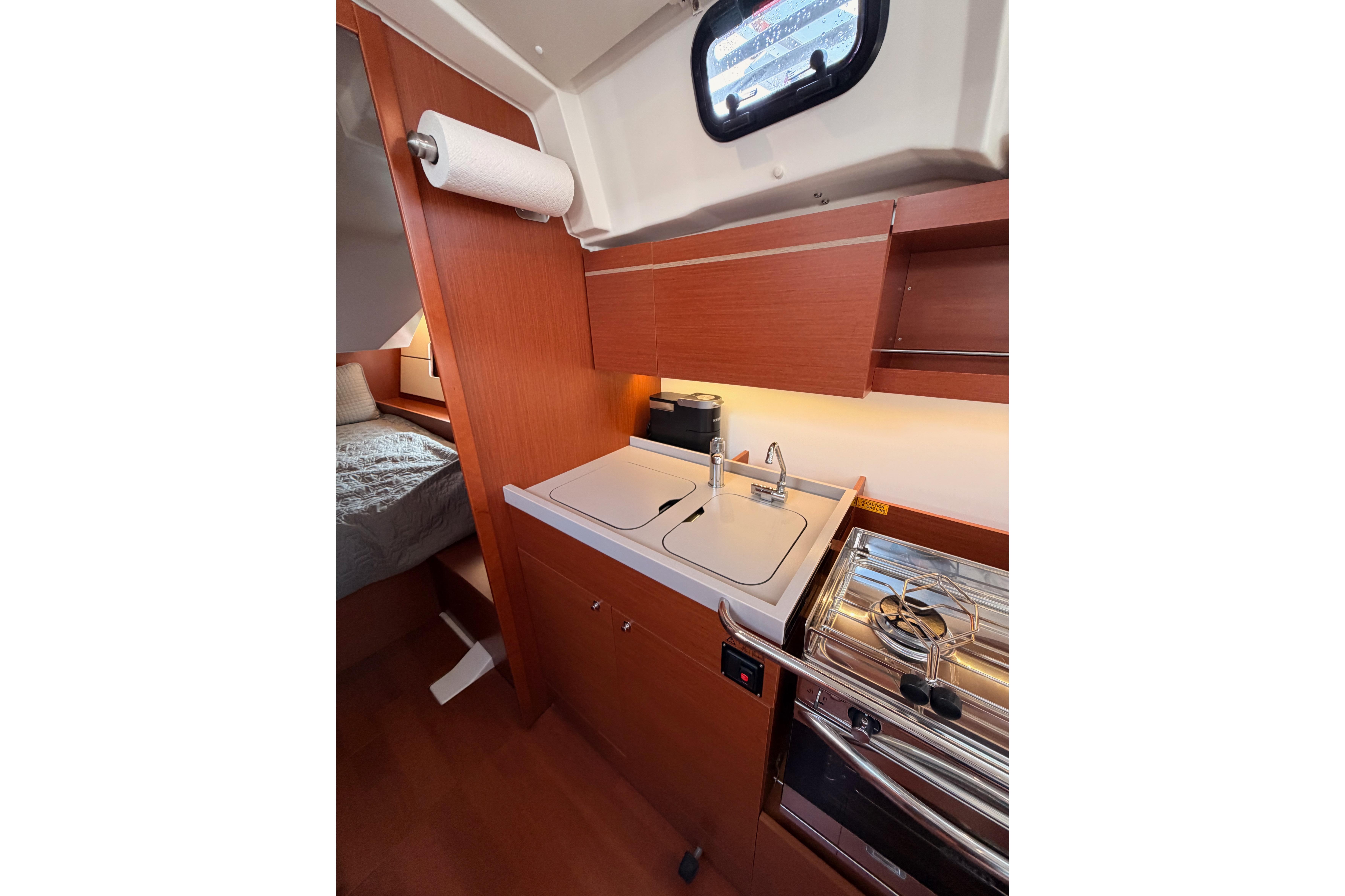 Interior of 2020 Beneteau Oceanis 46.1 yacht kitchen with sink and stove.
