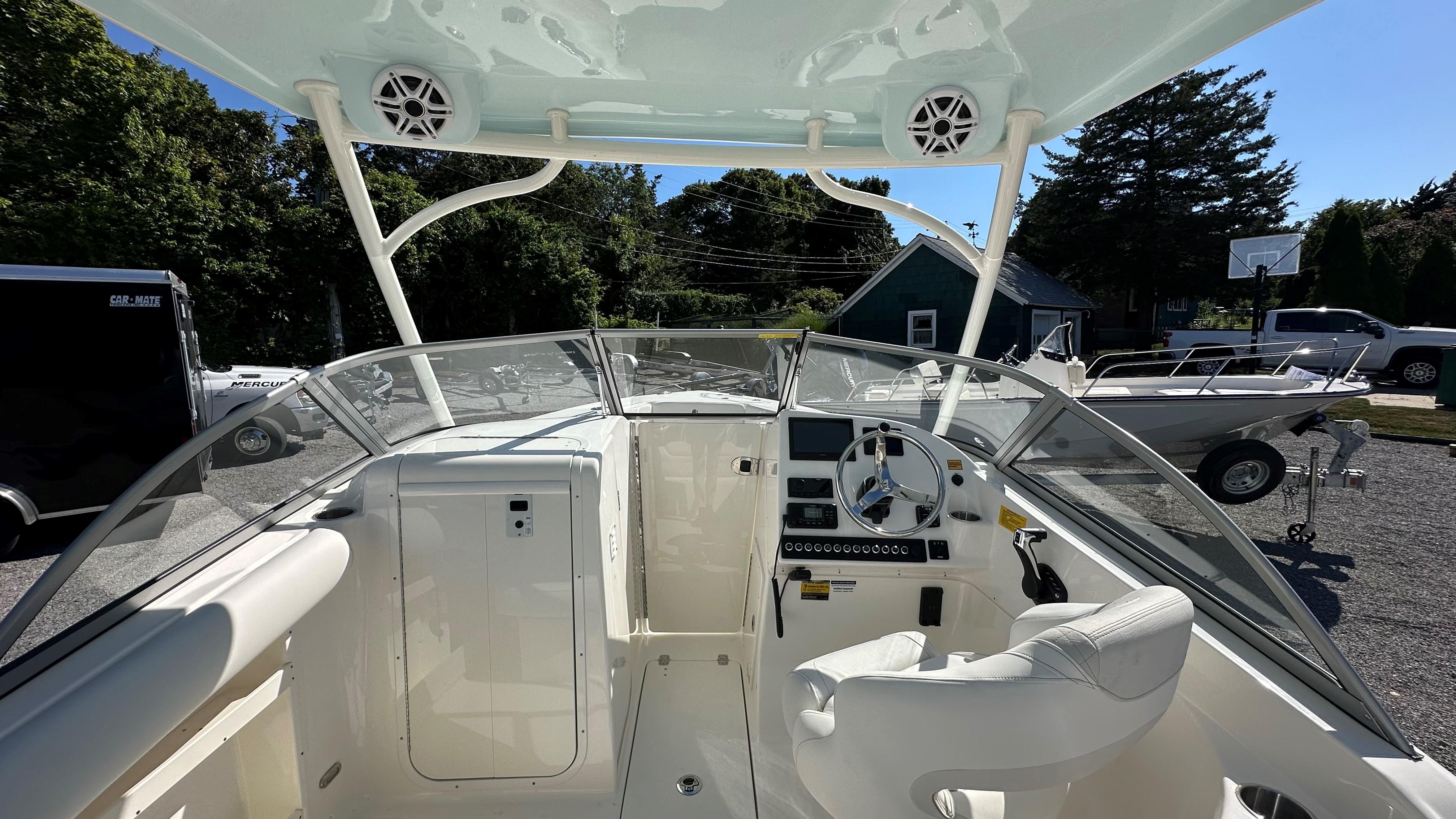 2026 Key West 239 DFS boat interior with steering wheel and dashboard, parked outdoors.