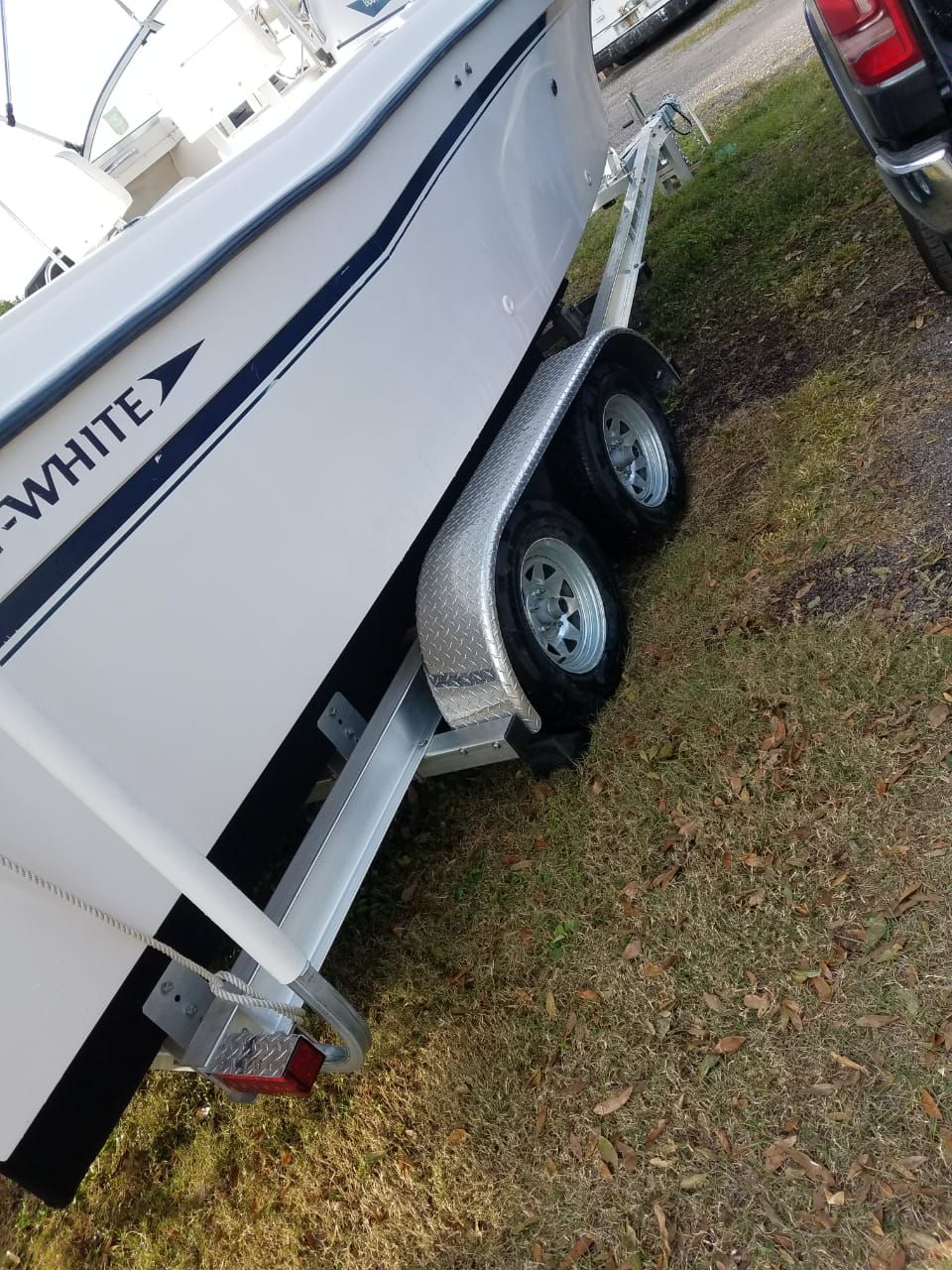 A 1995 Grady-White Explorer 24 on a trailer, parked on grass.