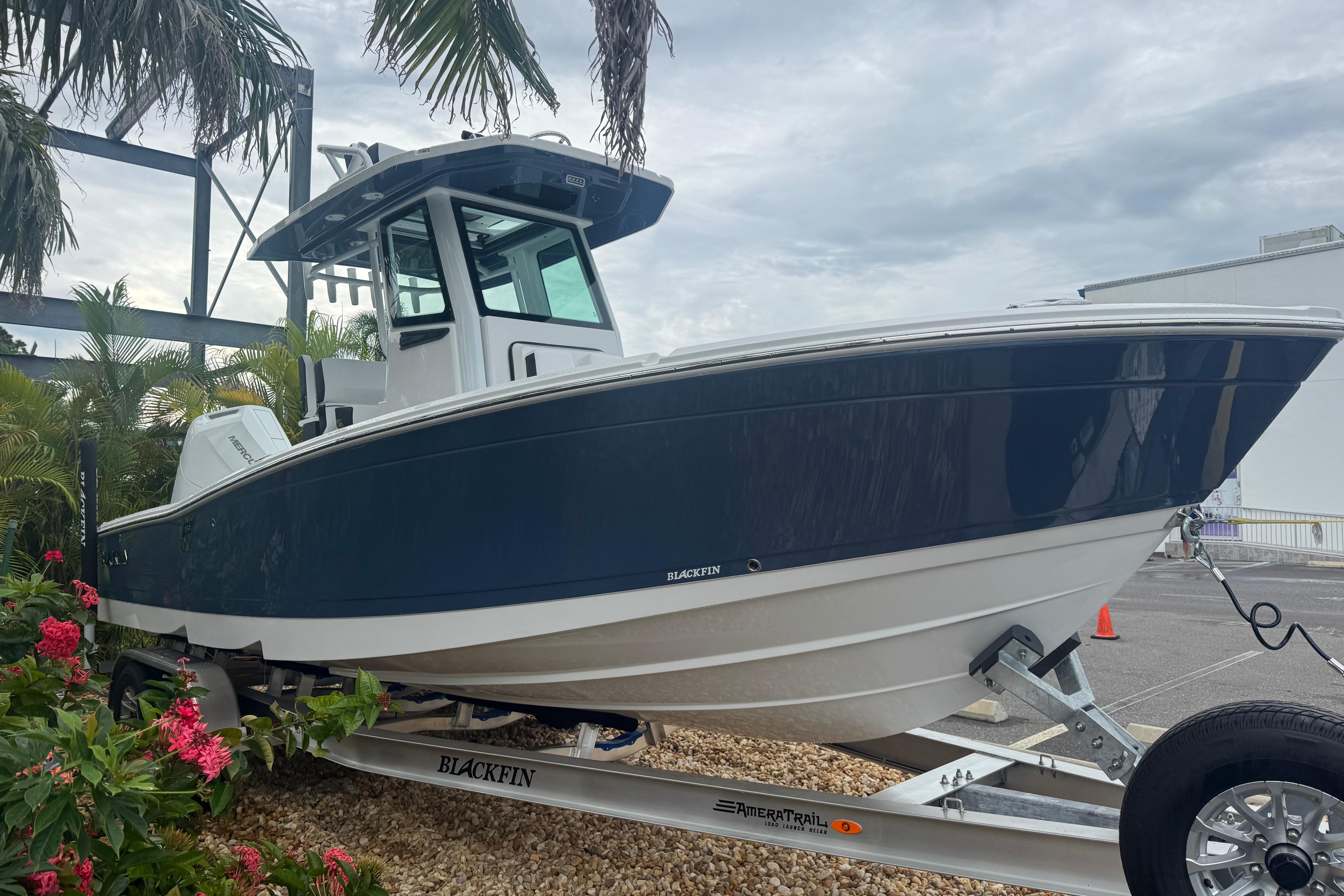 2026 Blackfin 262 HB boat on trailer, surrounded by tropical plants.