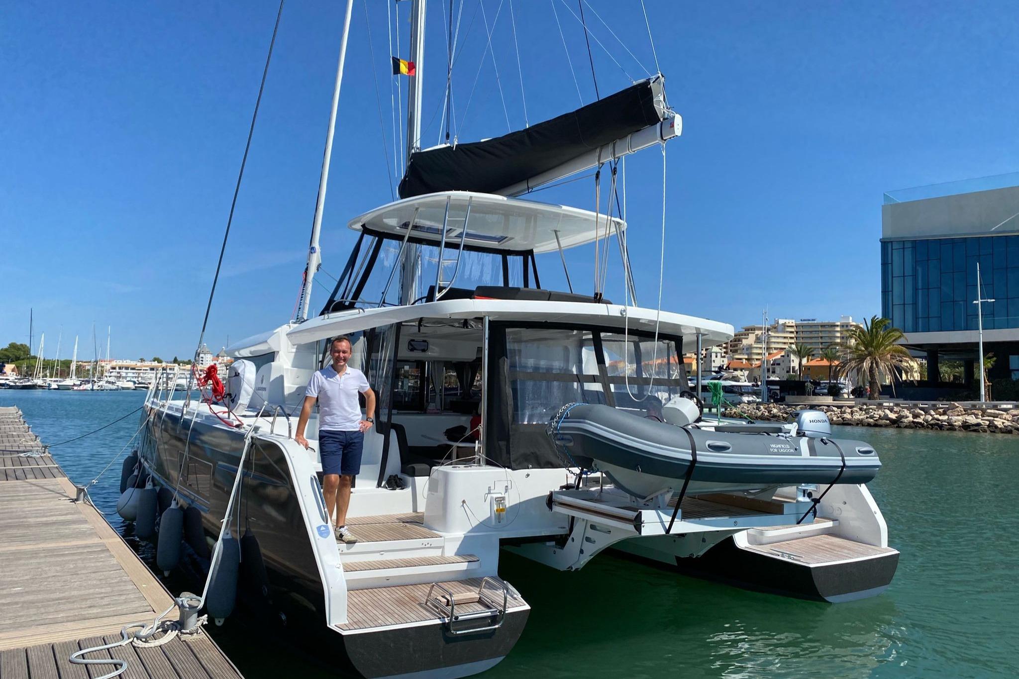 2020 Lagoon 46 catamaran docked at marina with person standing on deck.