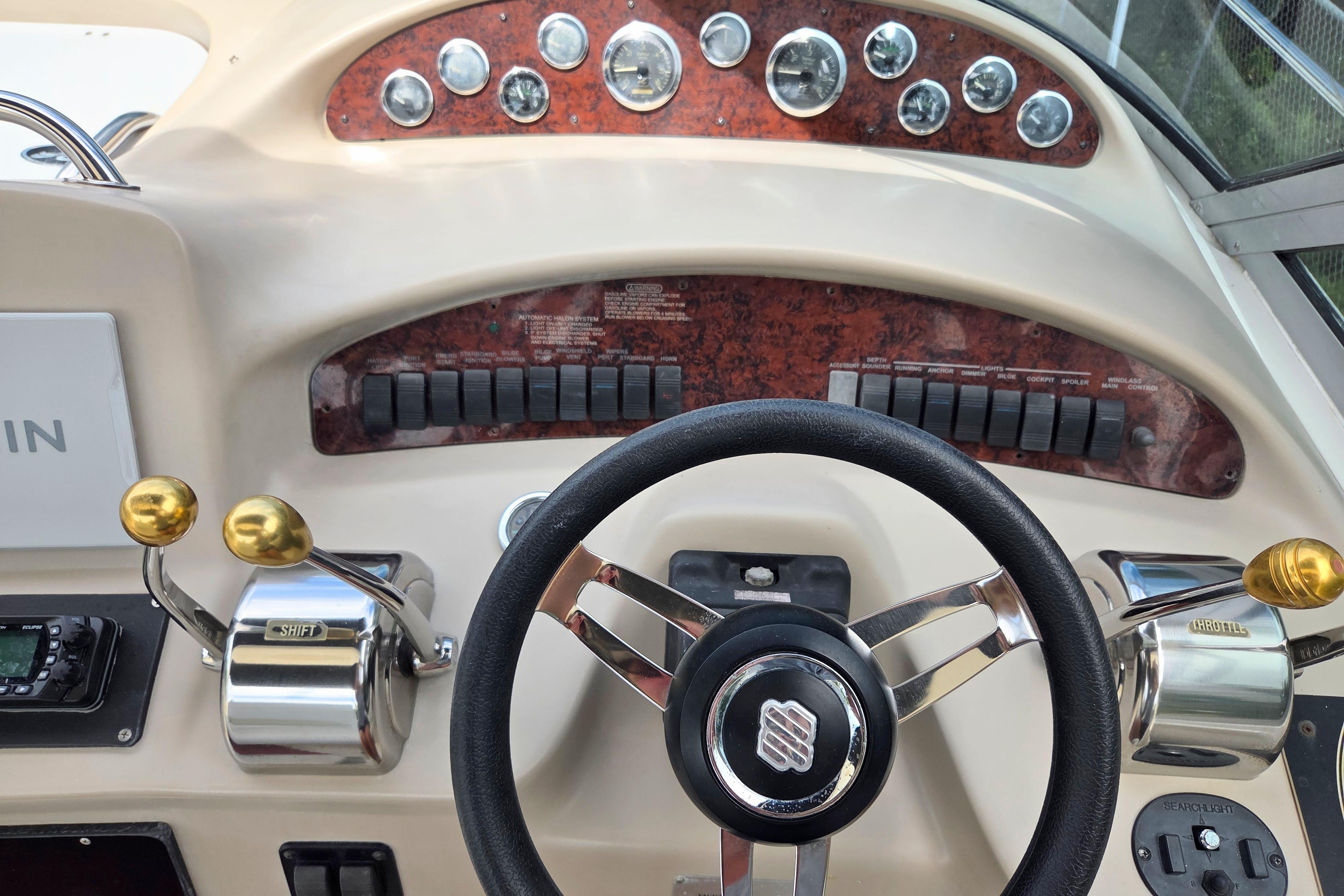 Steering console of a 2000 Sea Ray 340 Sundancer boat with controls and gauges.