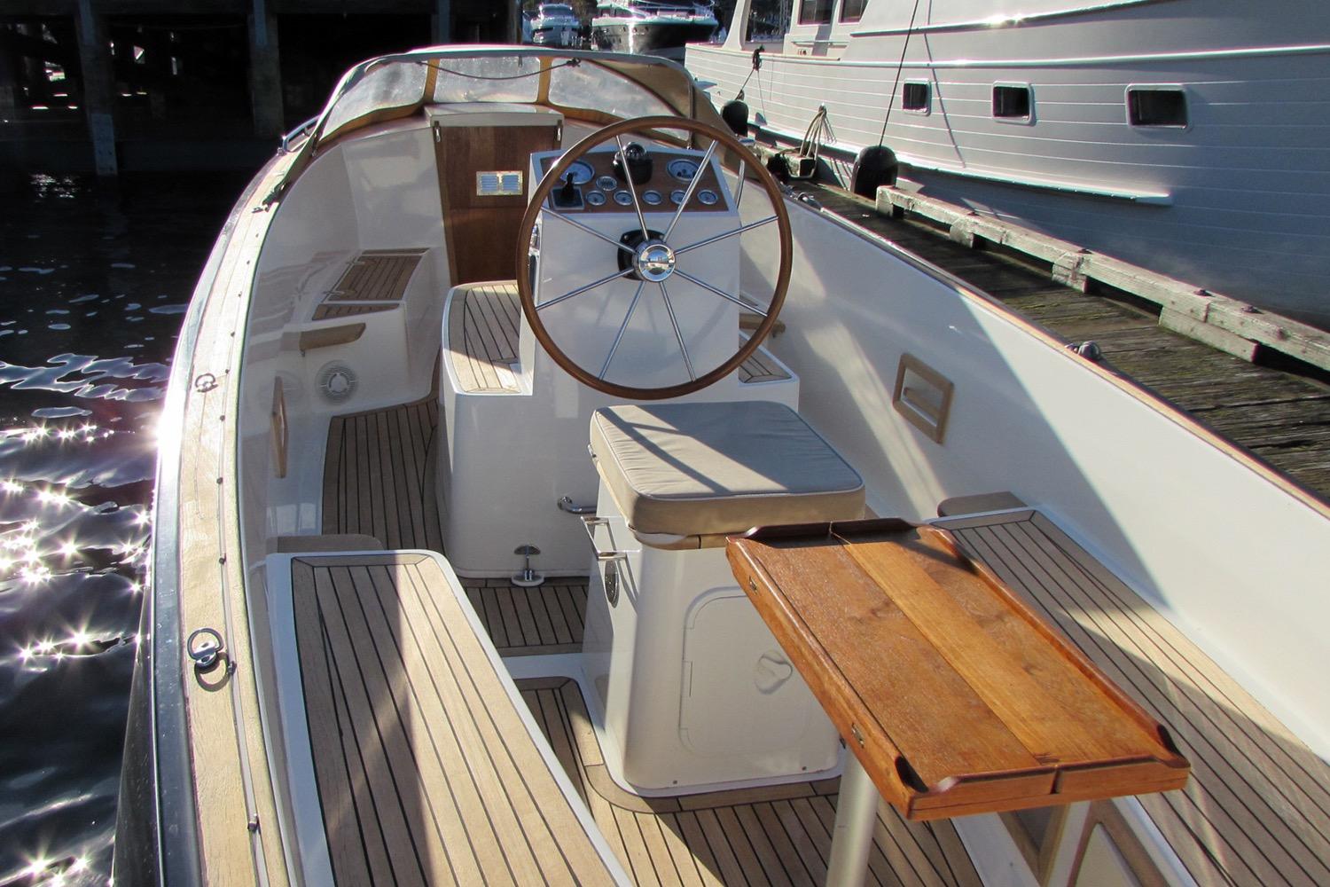 2014 AdmiralsTender C28 boat interior with wooden steering wheel and seating.
