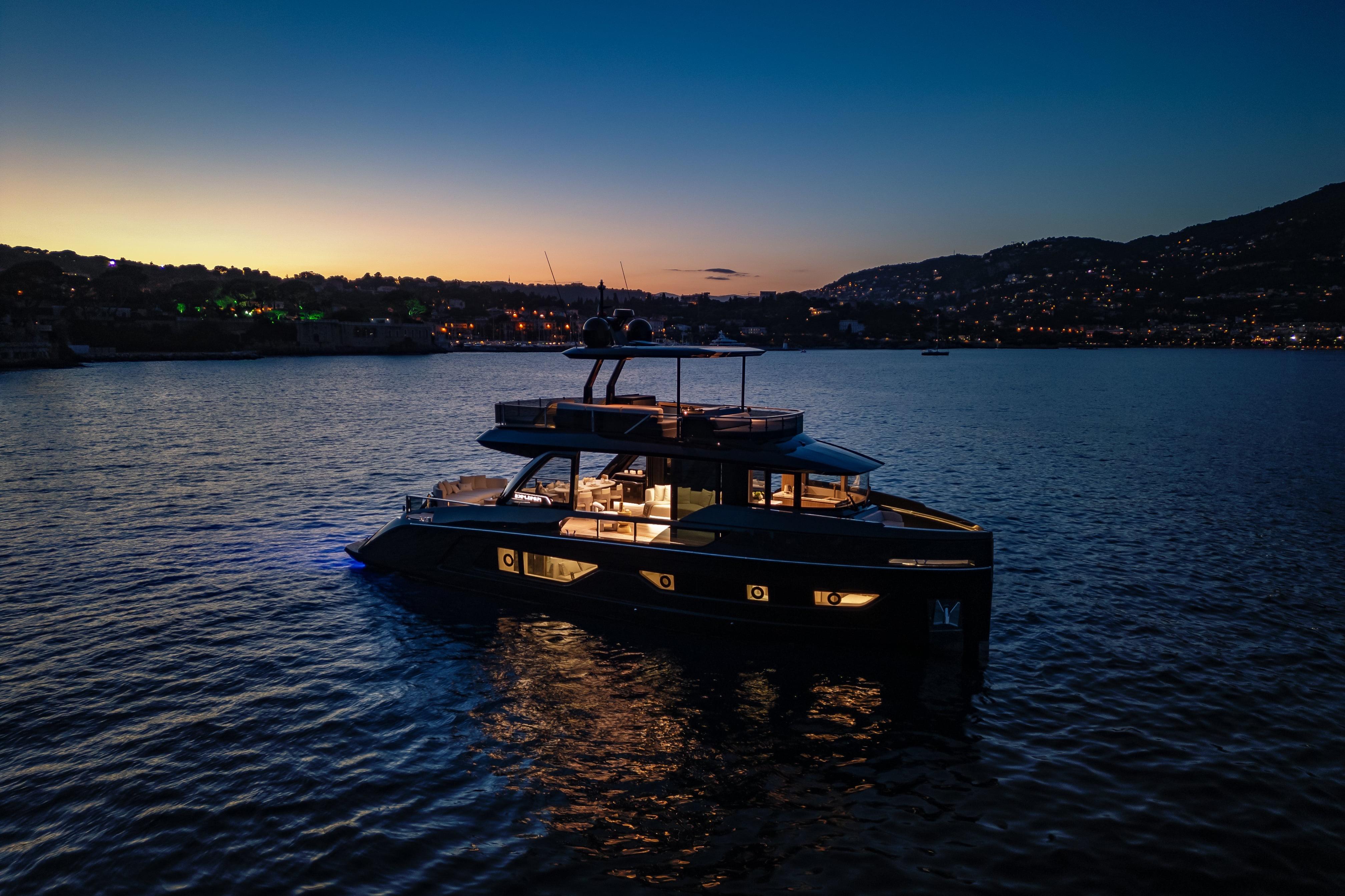 Luxurious 2025 Explorer 62 yacht illuminated at sunset on tranquil waters.