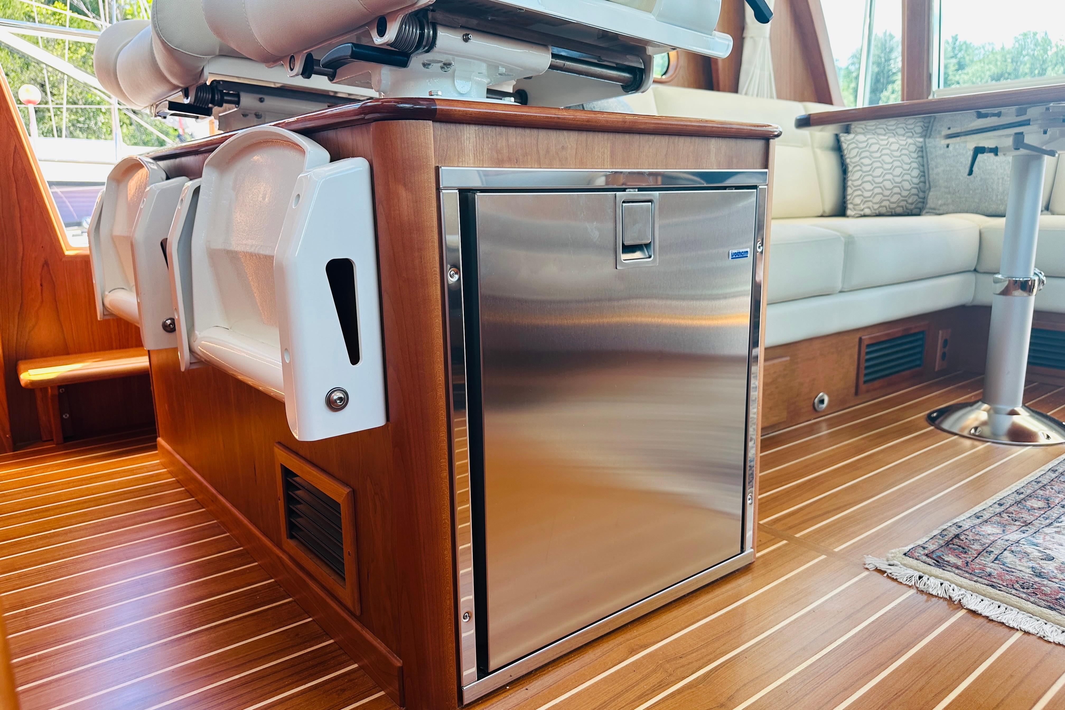 Interior of 2025 Sabre 48 Salon Express yacht with sleek wood finish and stainless steel fridge.