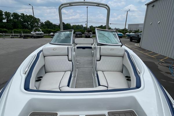 2023 Crownline E235 boat with spacious seating and sleek design in a marina setting.
