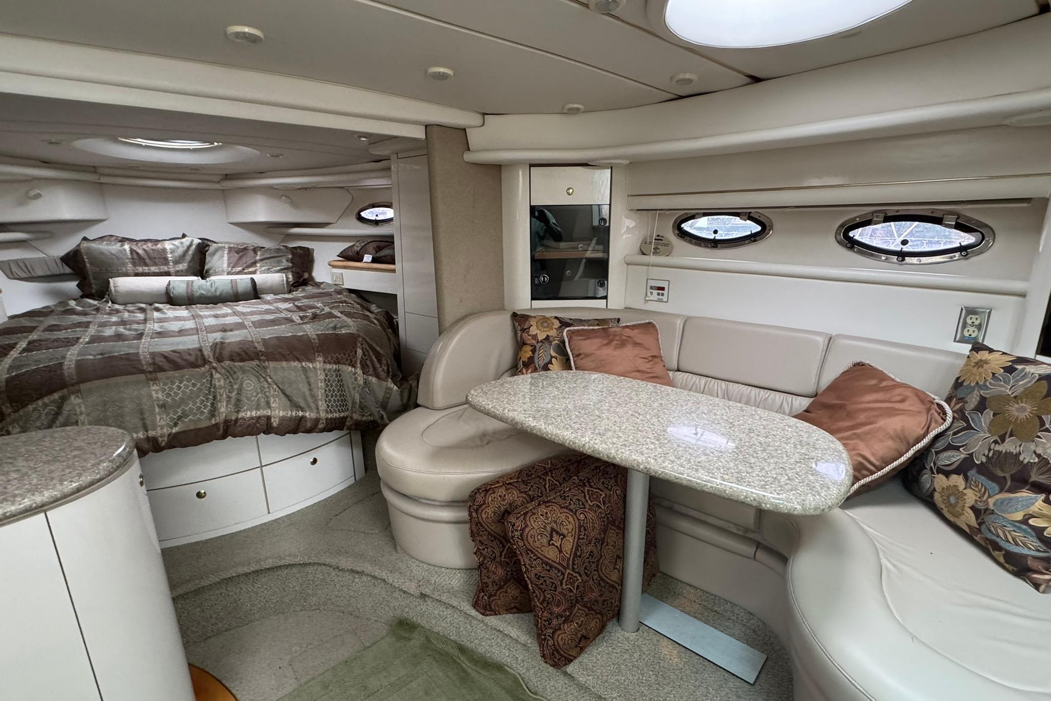 Luxurious interior of 1998 Maxum 3700 SCR yacht with cozy seating and elegant bedding.