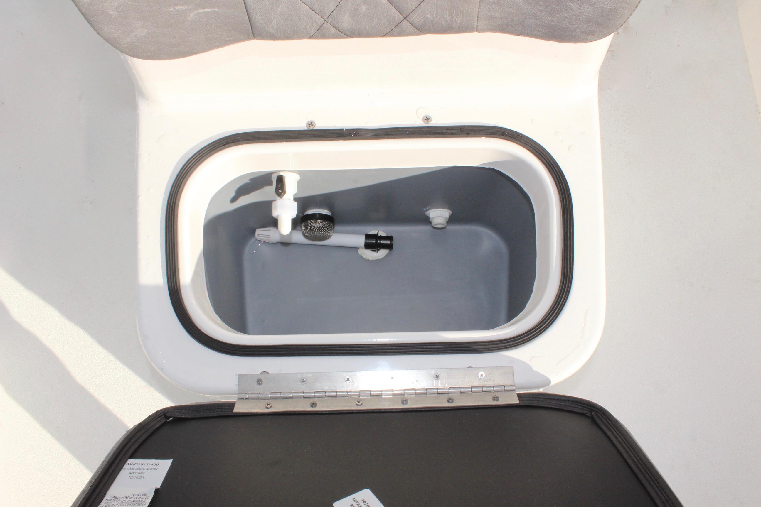 Avid 18 Rogue CC 2025 boat storage compartment with open lid, showcasing interior details.