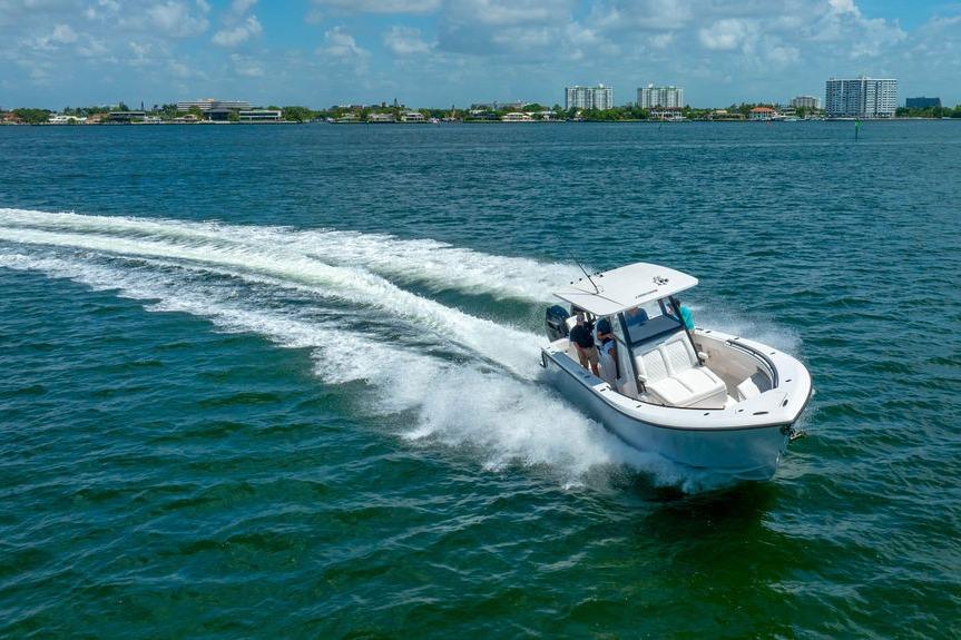 2027 Reef Runner 340 boat cruising on open water under a clear blue sky.