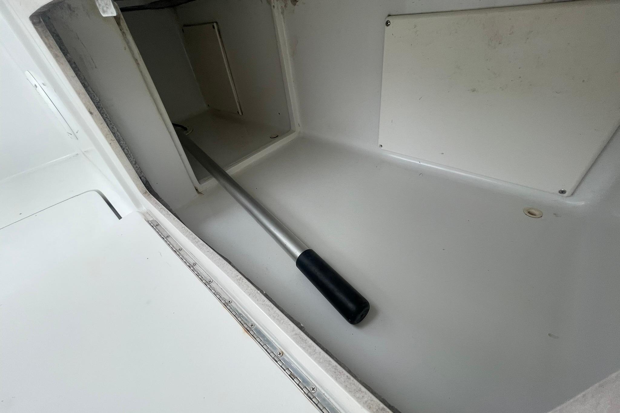 Storage compartment on a 1996 Luhrs Tournament 290 Open boat with a handle inside.