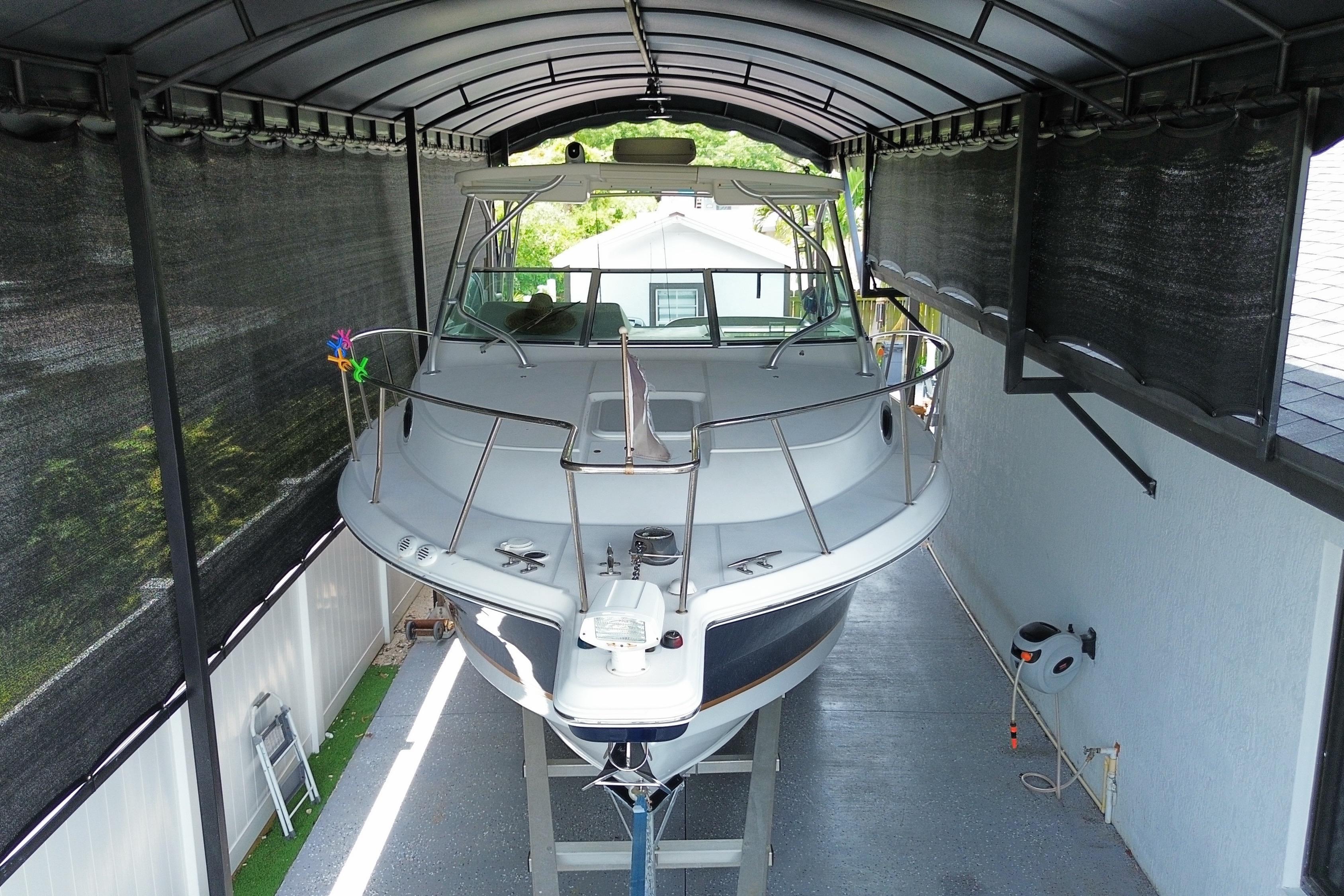 2005 Wellcraft 290 Coastal boat stored under a covered shelter.