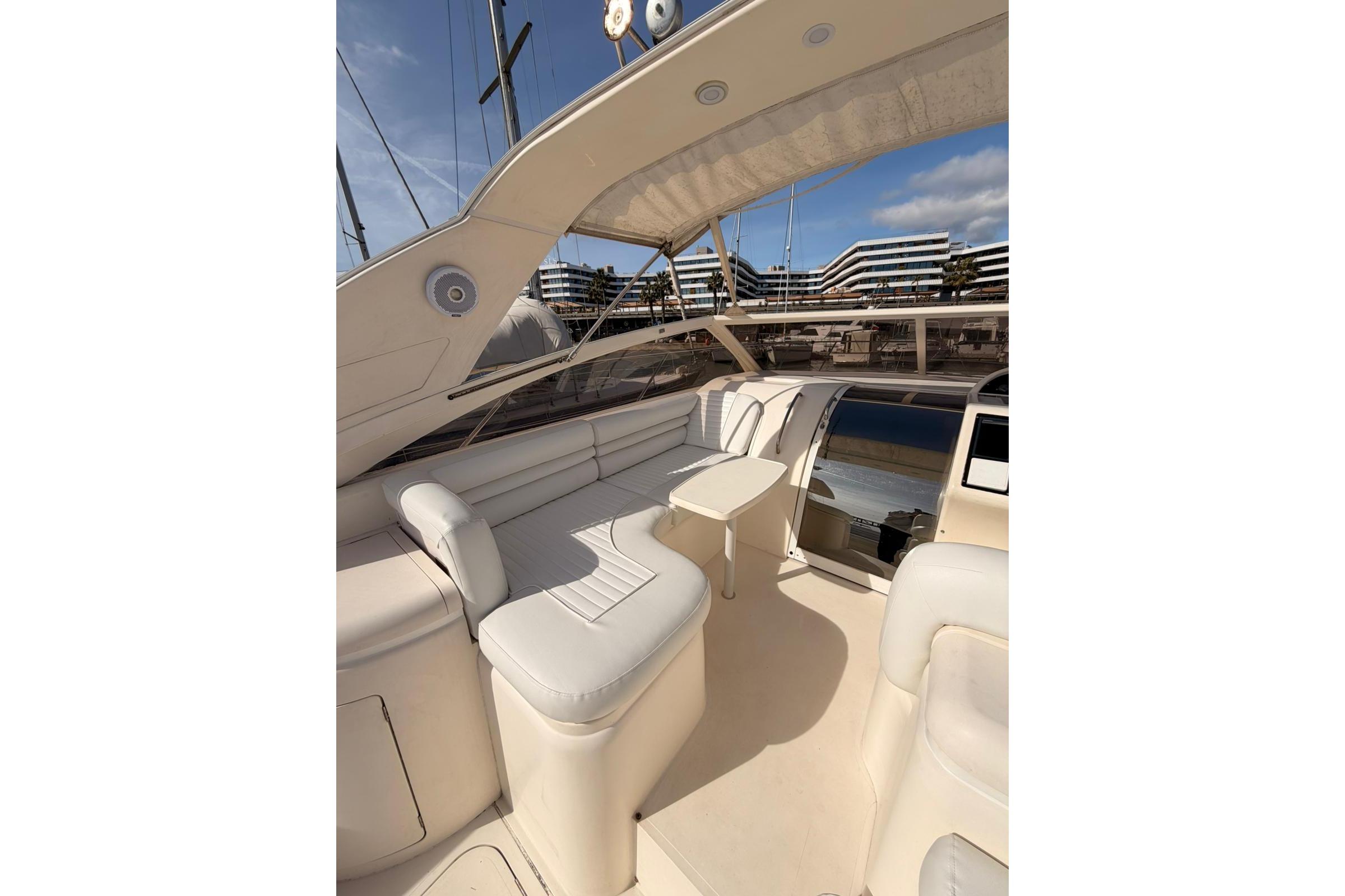Luxurious interior of 1996 Princess V39 yacht with cream leather seating and table.