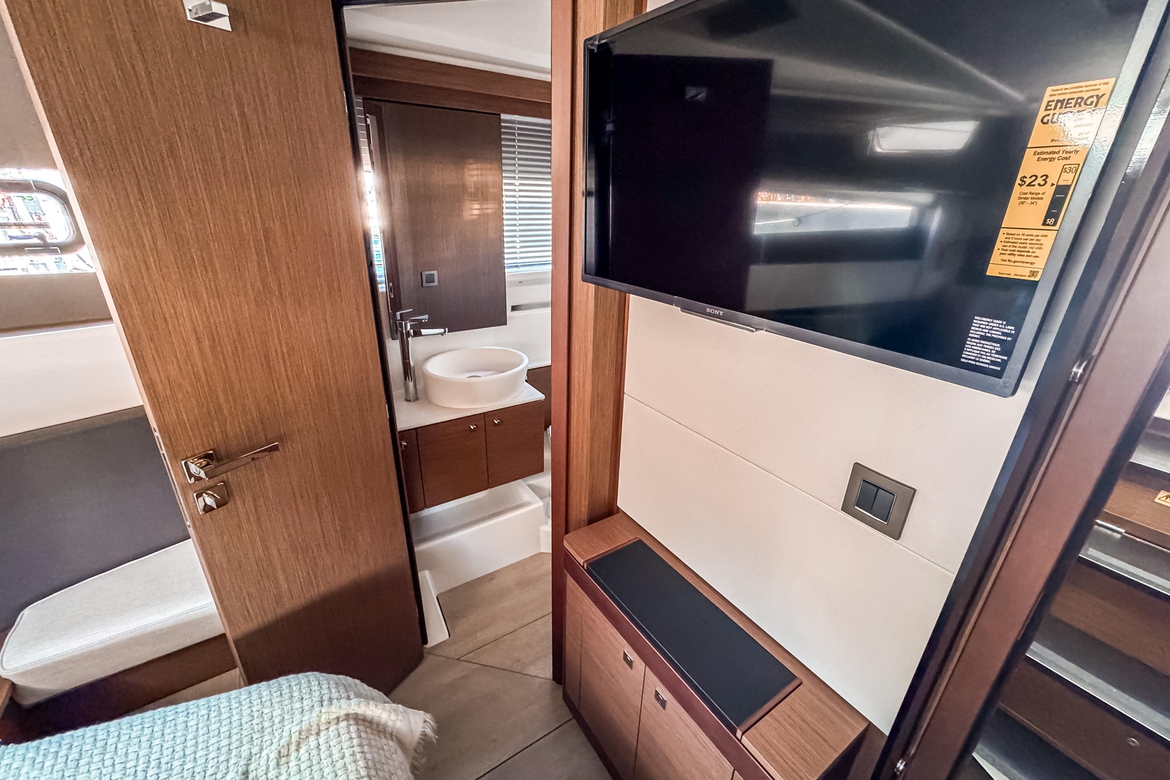 Interior of 2026 Wellcraft 44 Explorer yacht with TV and bathroom.