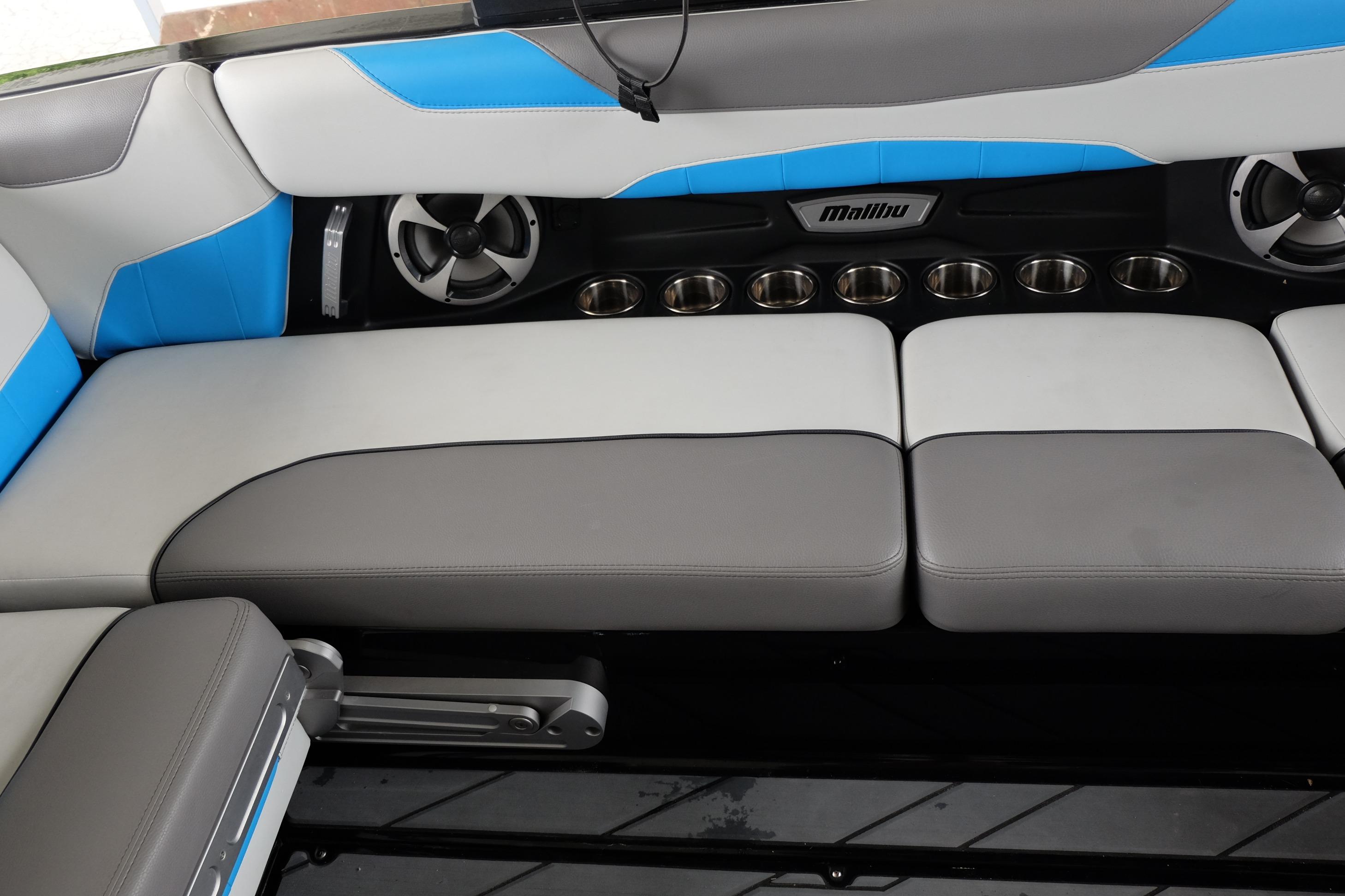 2020 Malibu Wakesetter 23 LSV interior with gray and blue seating, cup holders, and speakers.