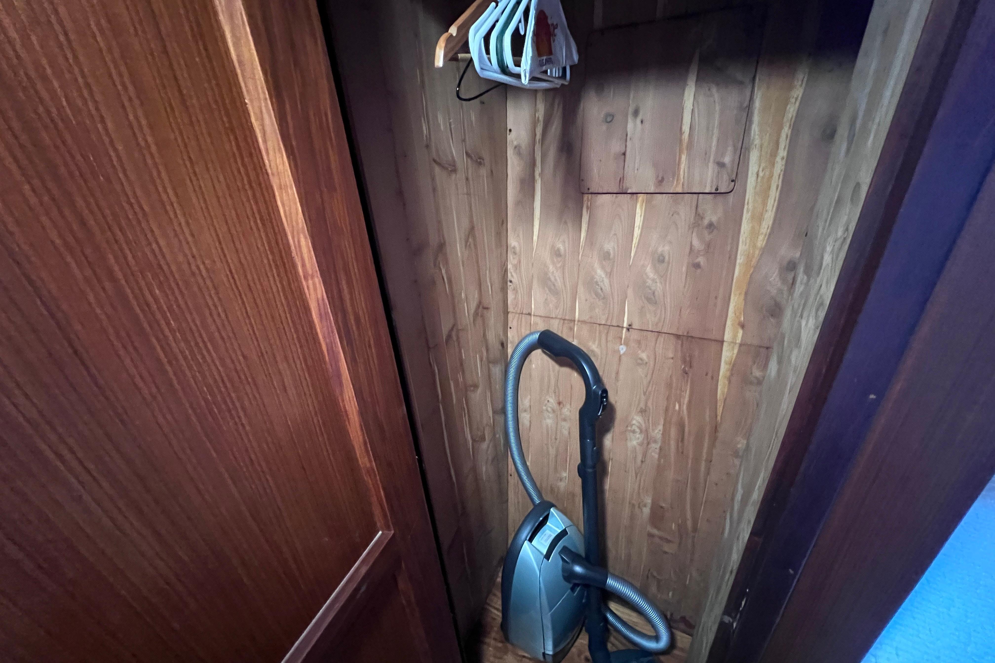 Wooden closet with vacuum cleaner and hangers on Hatteras 70 Cockpit Motor Yacht, 1987.