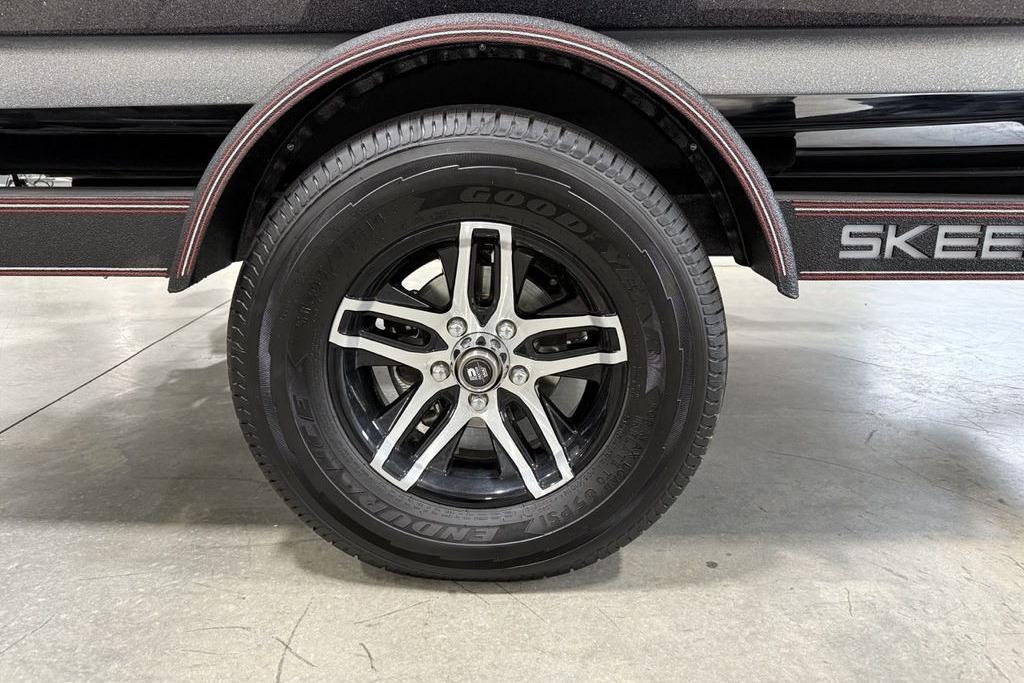 2025 Skeeter ZX150 trailer wheel with Goodyear tire, showcasing sleek black and silver alloy rim.