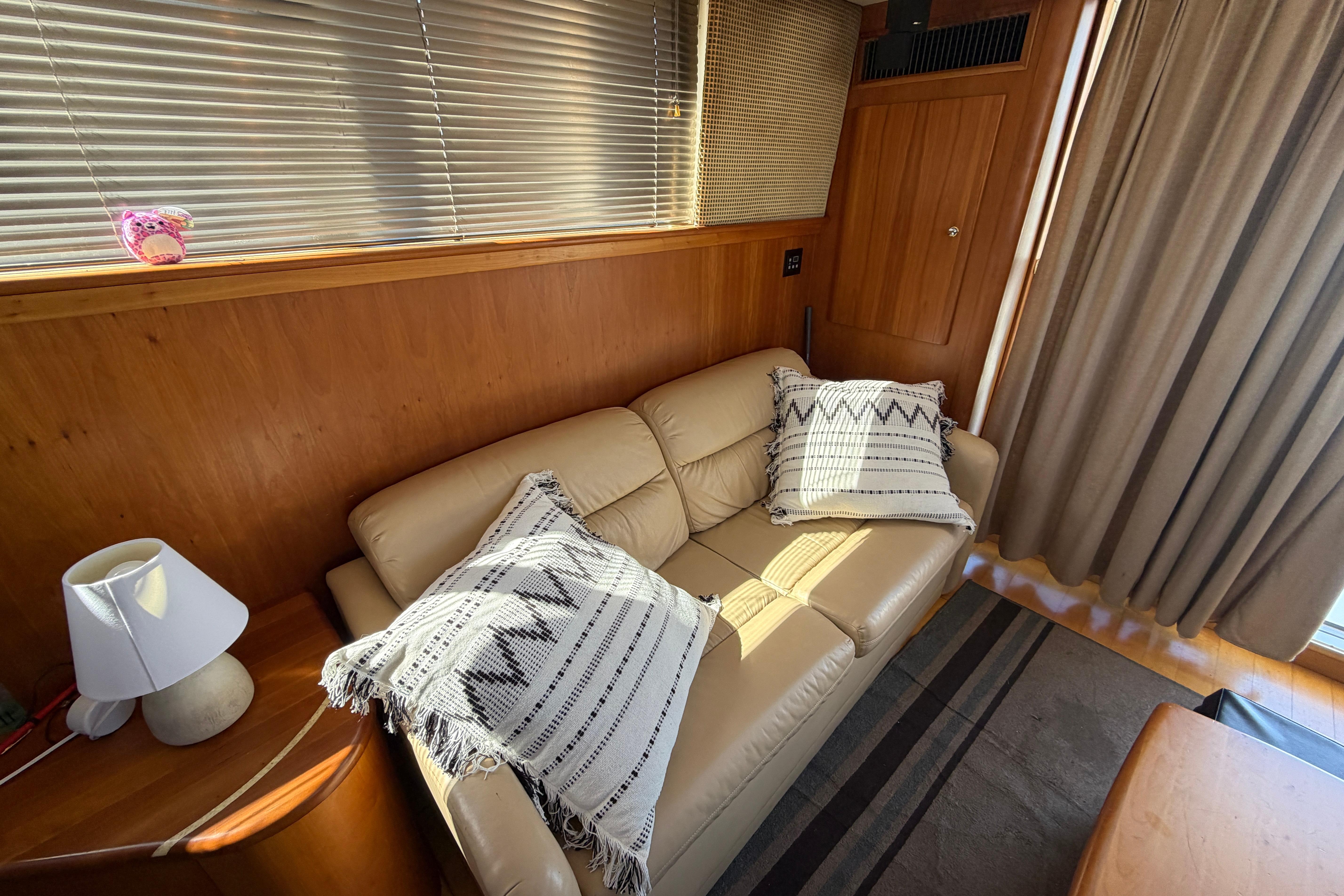 Interior of 2001 Silverton 42 Convertible yacht with beige sofa and decorative pillows.