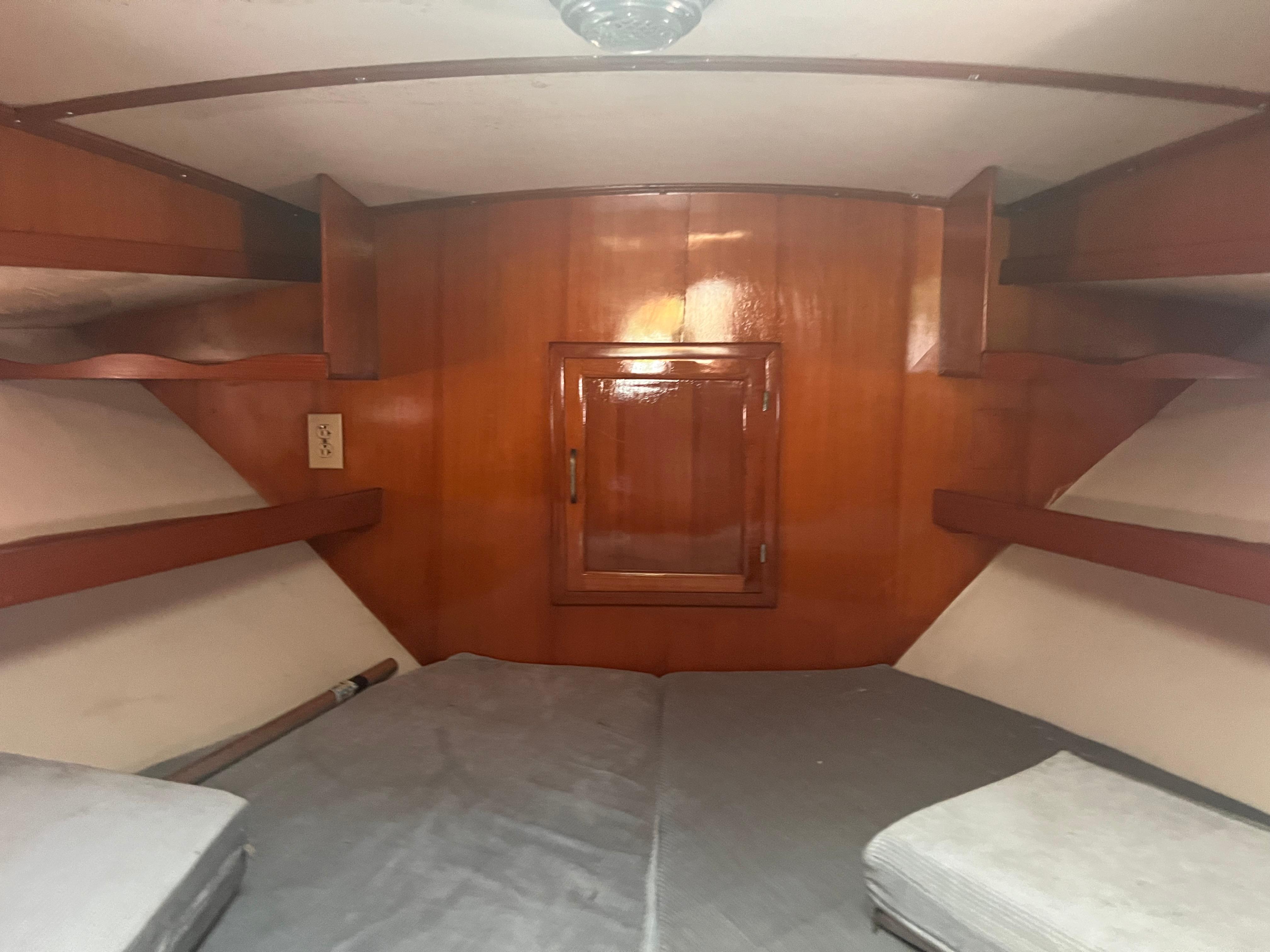 Interior cabin of 1988 Canyon Bay 40 boat with wooden paneling and cushioned seating.