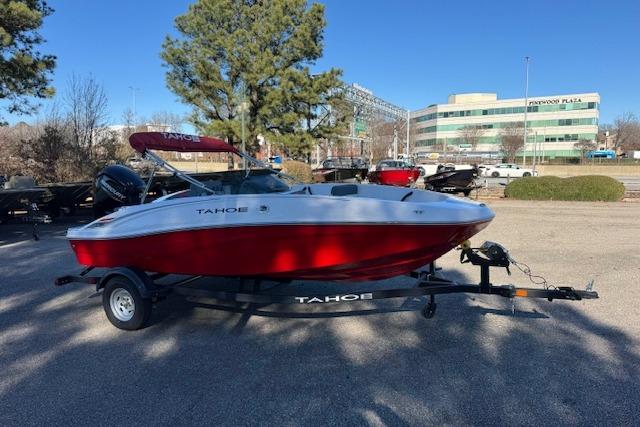 2026 Tahoe T16 boat with red and white design on a trailer in a parking lot.