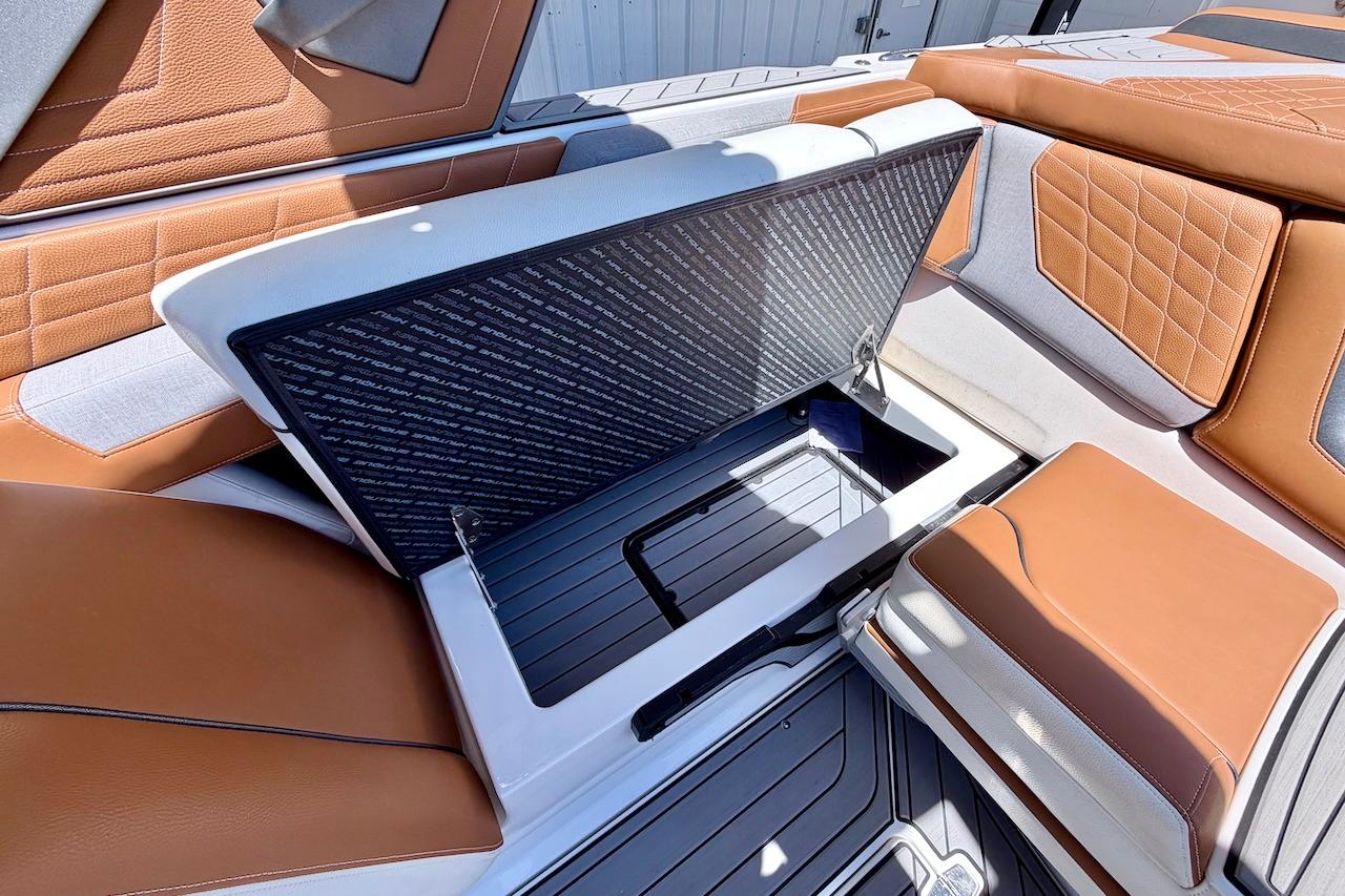 2021 Nautique Super Air Nautique G23 interior storage compartment with brown and white seating.