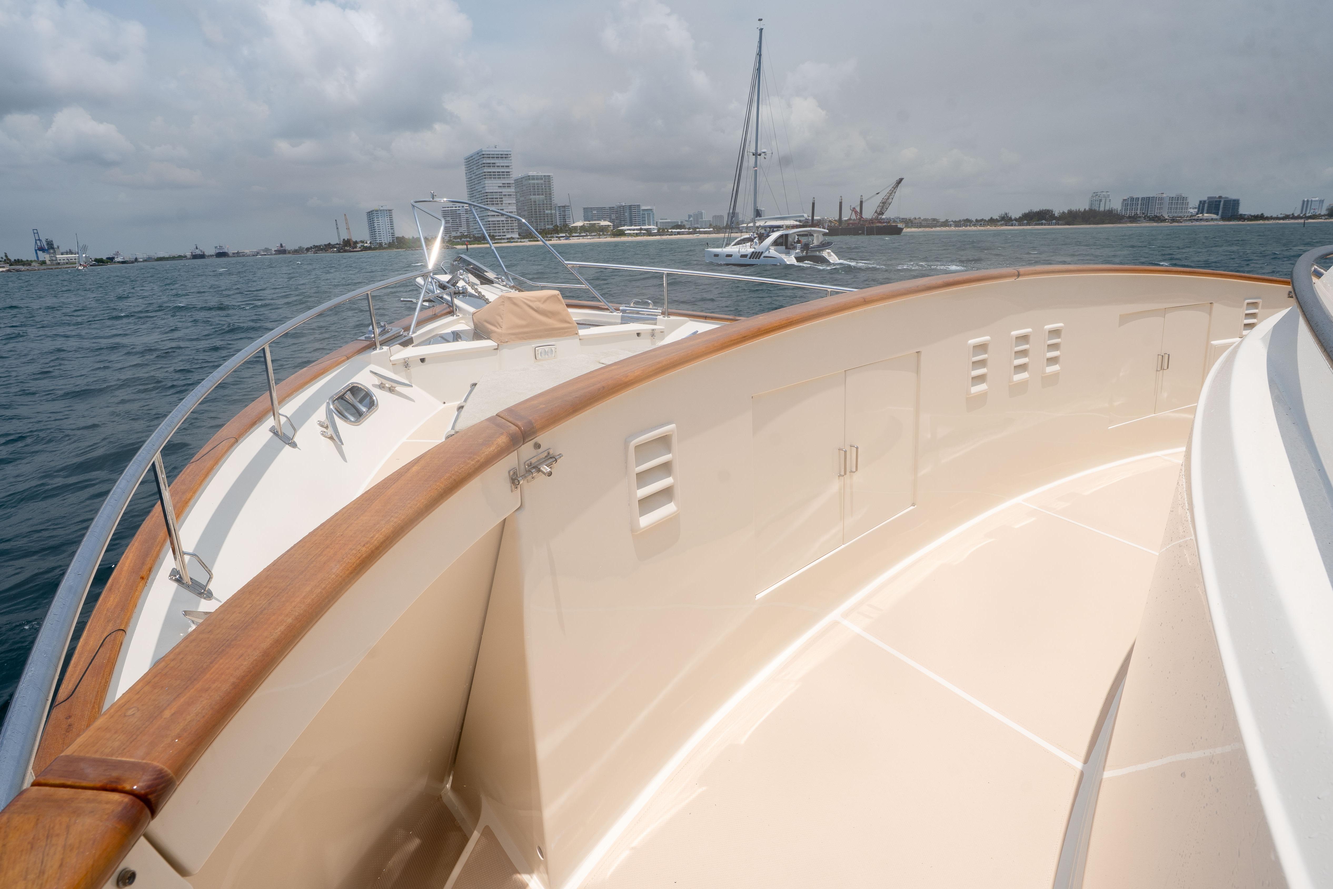 Bow view of 2006 Fleming 75 yacht on calm waters with city skyline.