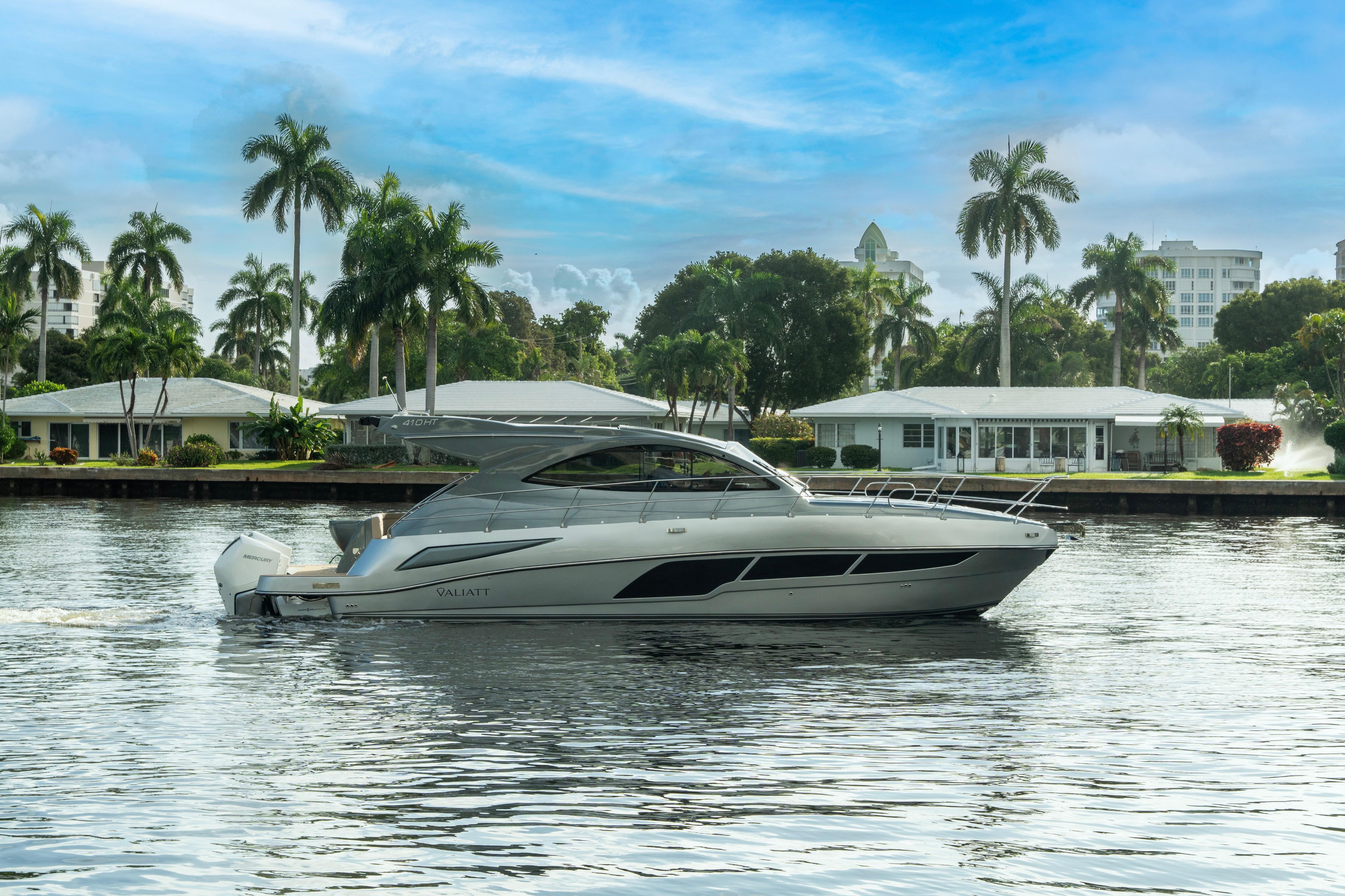2025 Valiatt 410HT luxury yacht cruising on a scenic waterway with palm trees.