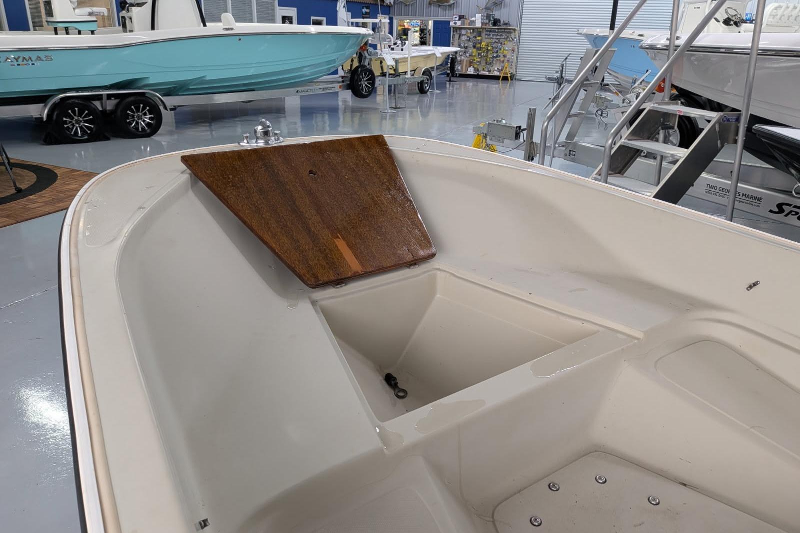 1978 Boston Whaler 15 SPORT boat interior in showroom with wooden hatch cover.