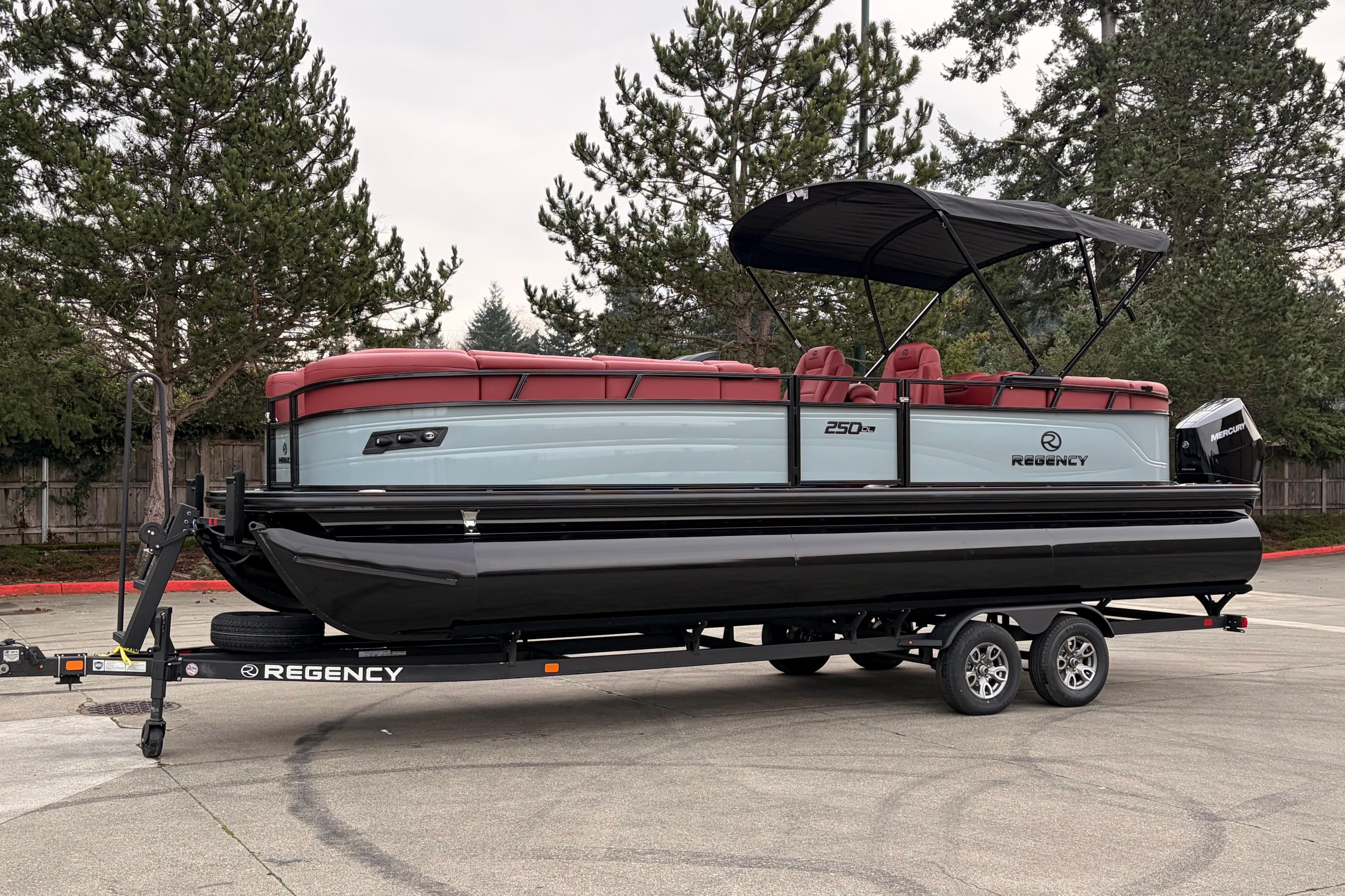 2026 Regency 250 DL pontoon boat on trailer, featuring red seating and black canopy.
