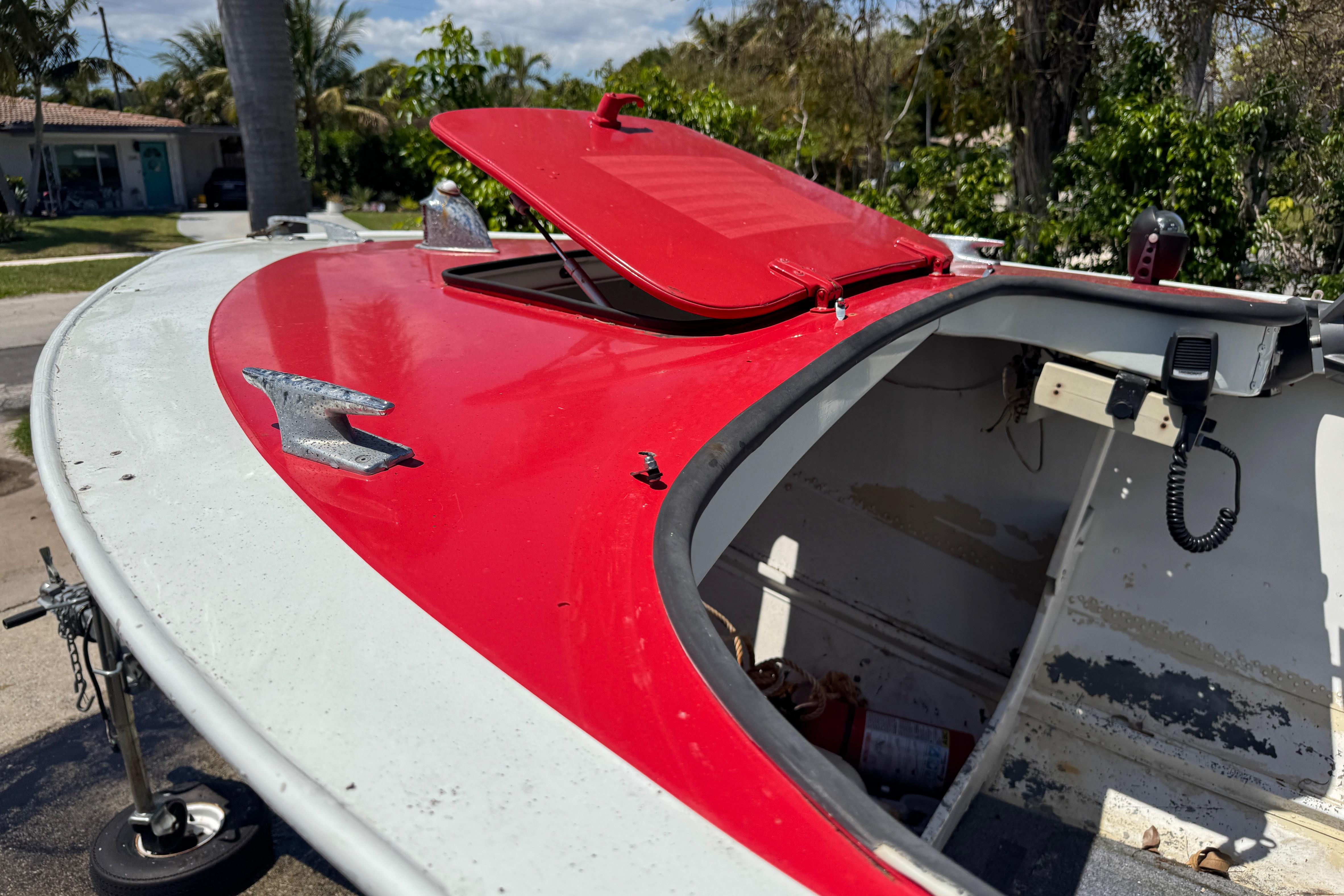 1960 Crestliner Wildwood 19 boat with red and white exterior, open hatch, and visible interior.