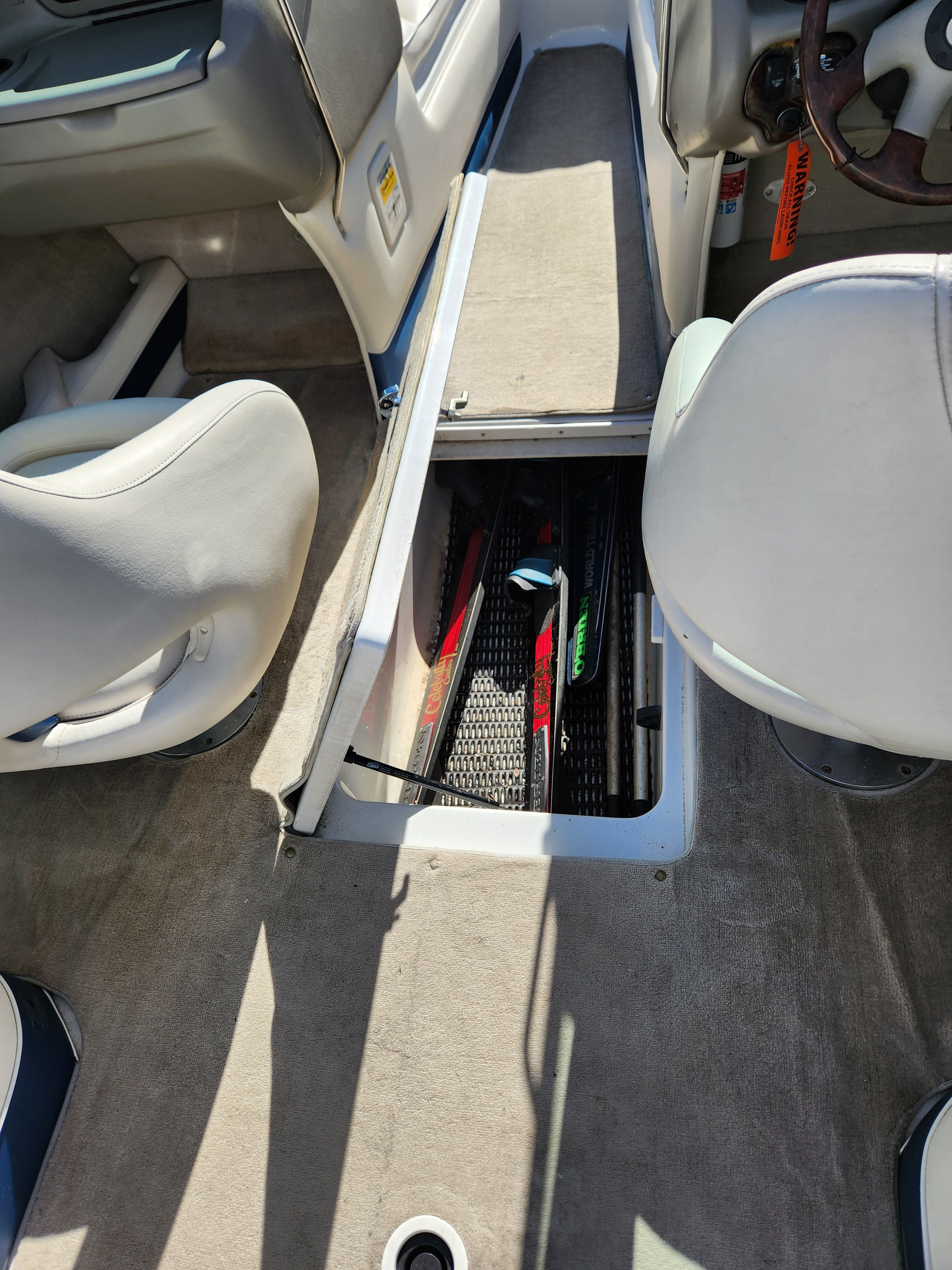 Interior of a 2003 Crownline 225 BR with storage compartment.