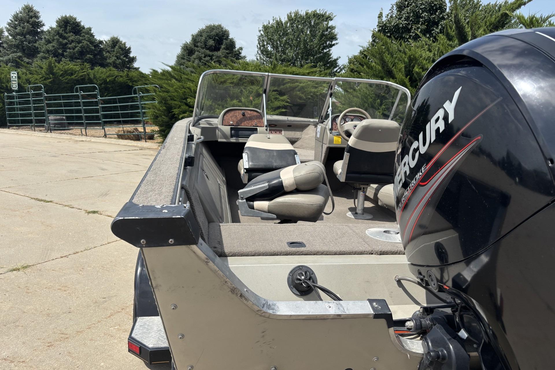 1999 Tracker Targa 18 boat with Mercury outboard motor, parked outdoors.