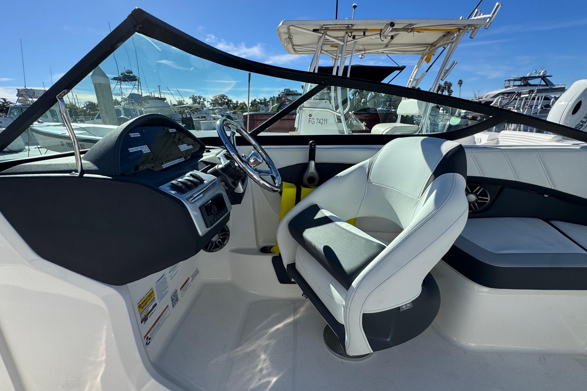 2026 Regal 21 OBX boat interior with steering wheel and seating, docked at marina.