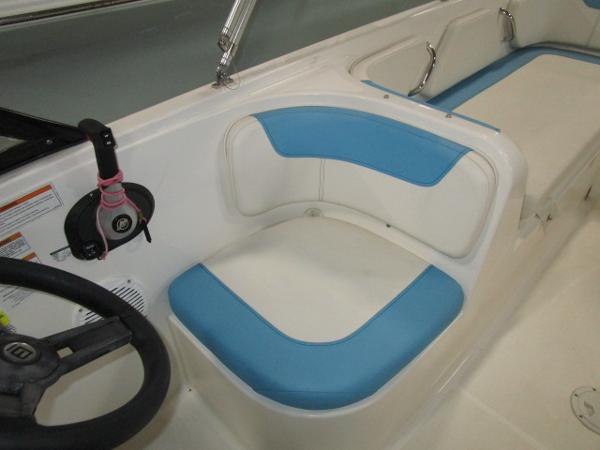 2023 Bayliner 210EL boat interior with blue and white seating and steering wheel.