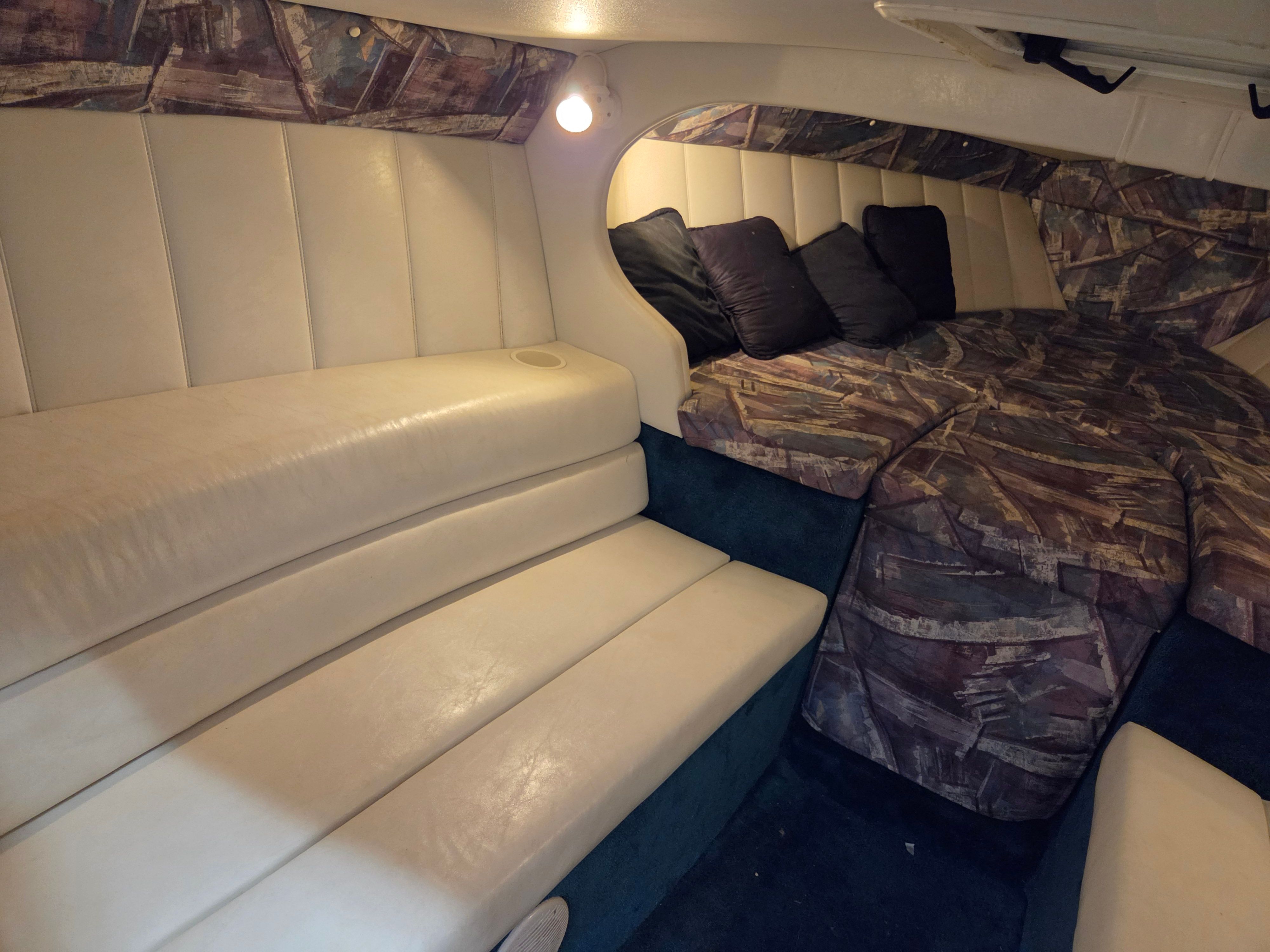 Interior of the 1998 Powerquest Enticer 290 FX with cushioned seating and sleeping area.