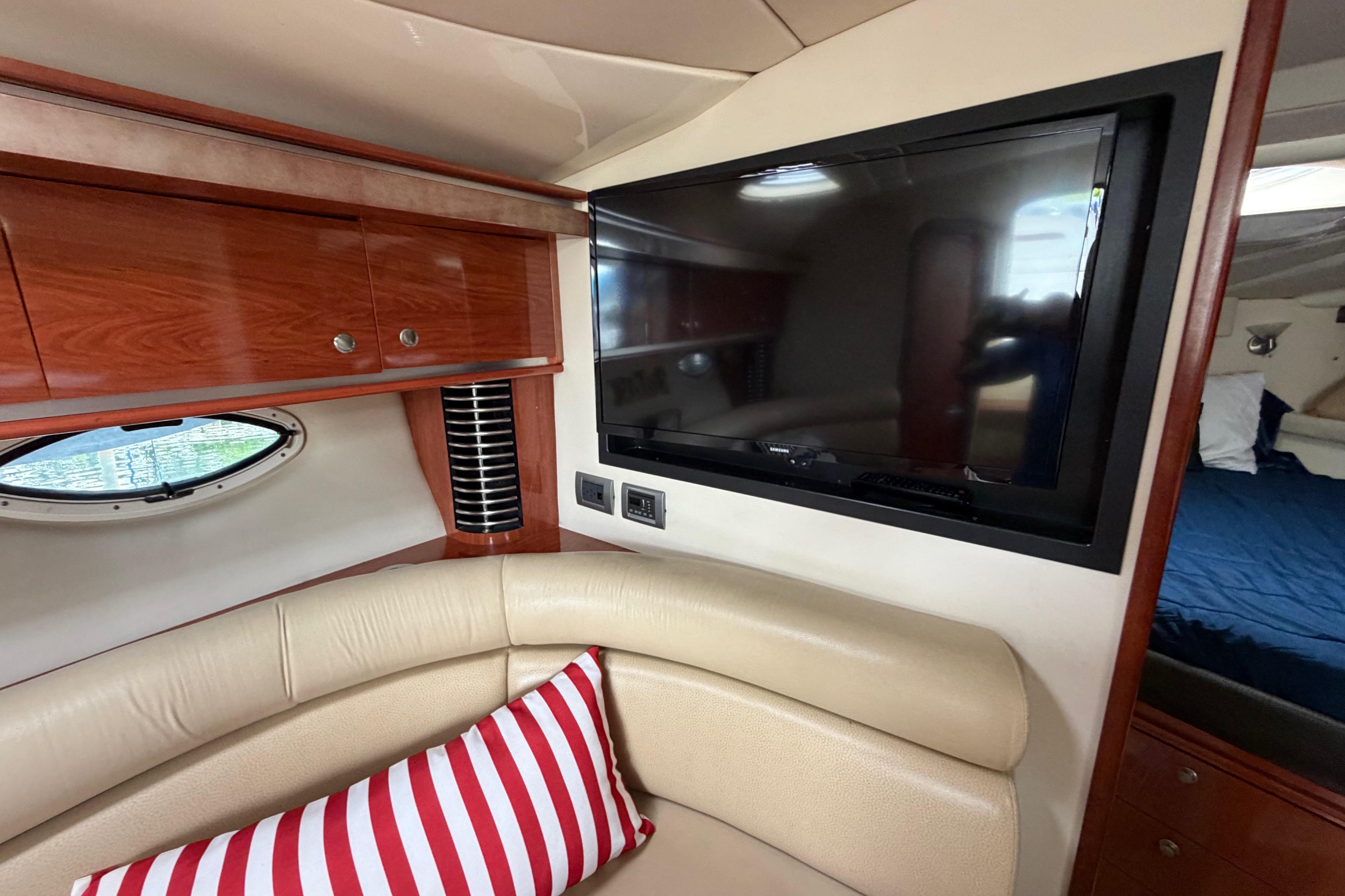 Interior of 2007 Monterey 350 Sport Yacht with TV and striped pillow.