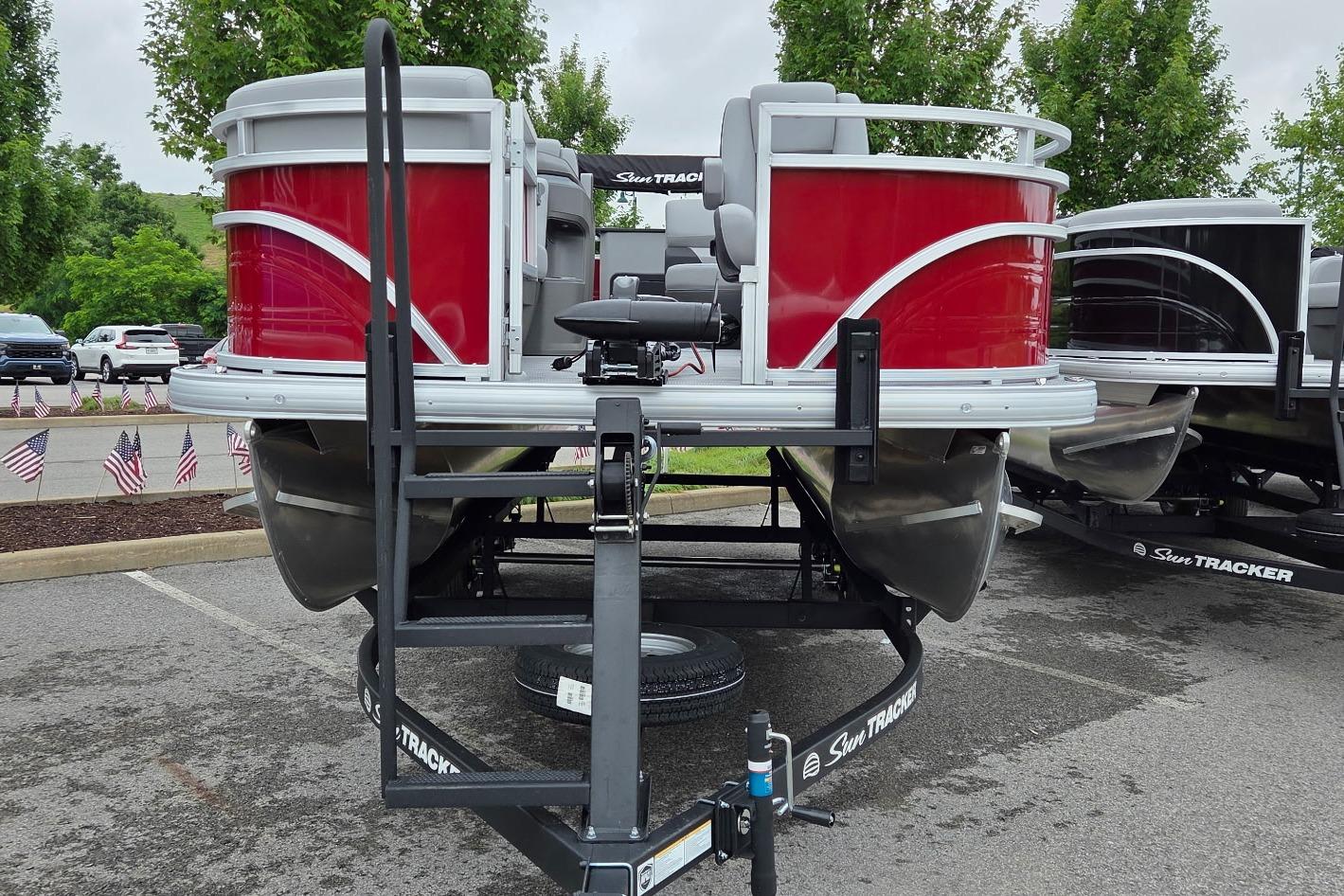2026 Sun Tracker SportFish 20 DLX pontoon boat with red exterior on display.