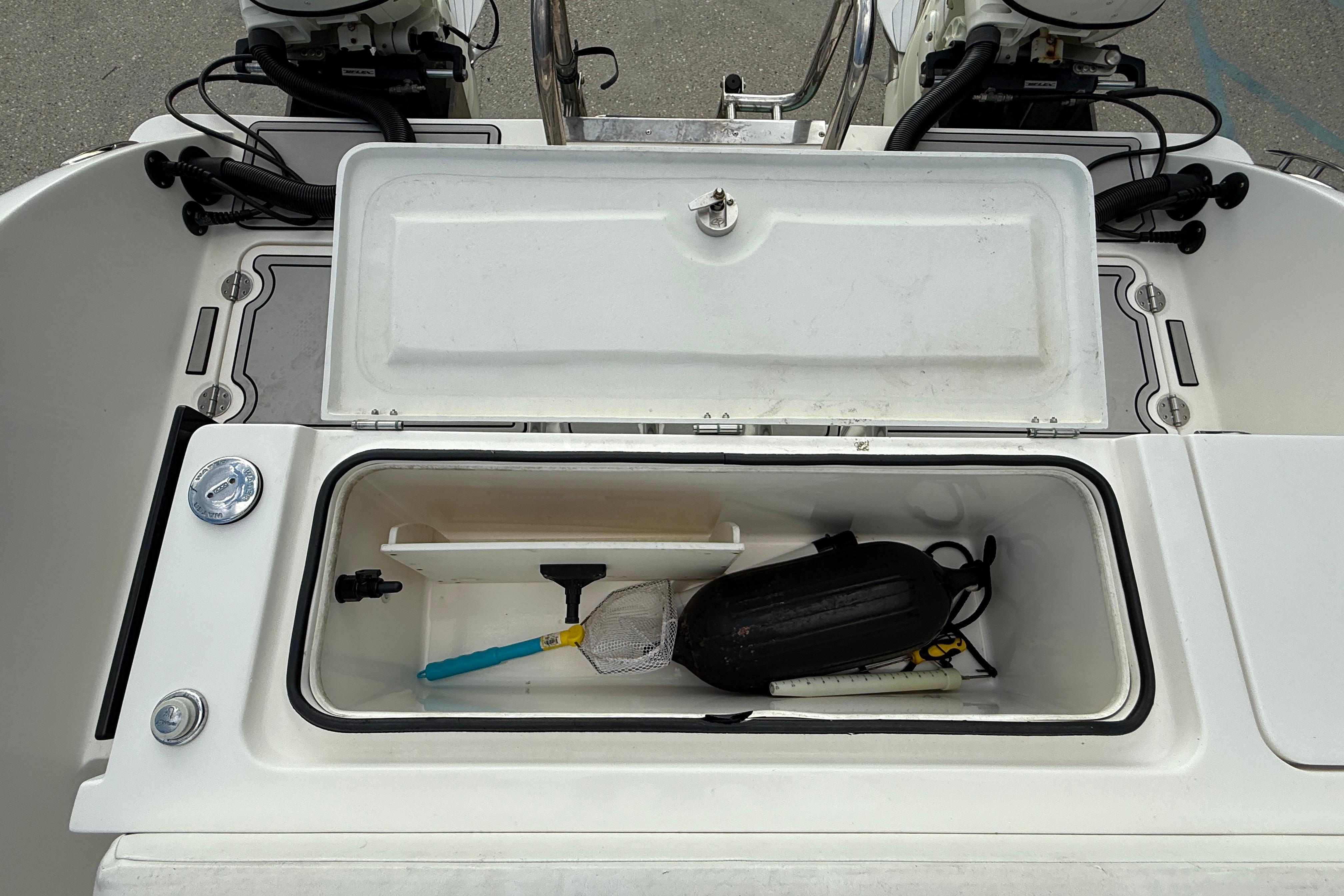 Open storage compartment on 2020 Twin Vee 240 GFX CC boat, containing various boating accessories.