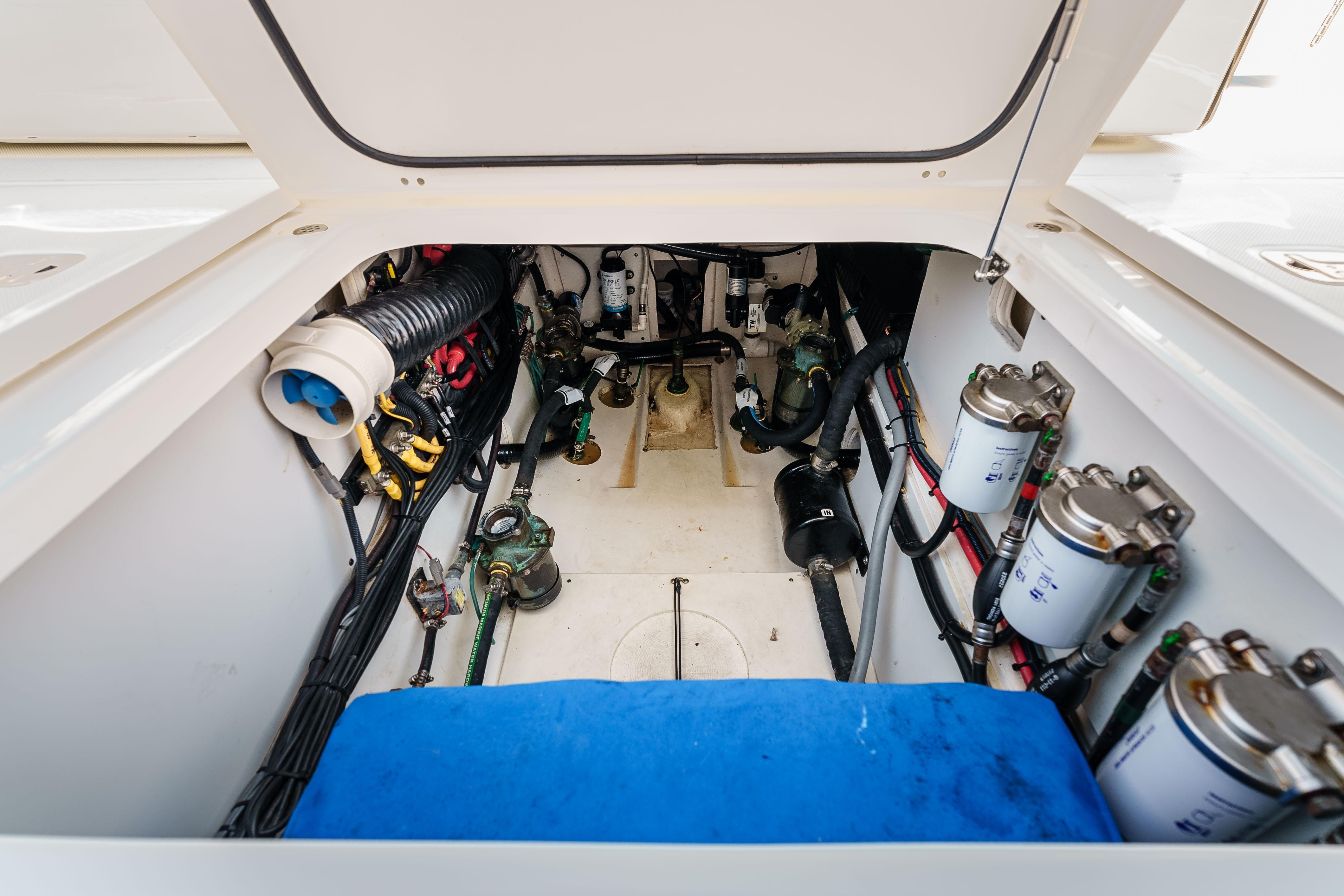 Engine compartment of 2022 Pursuit OS 385 Offshore boat, showcasing mechanical components and wiring.