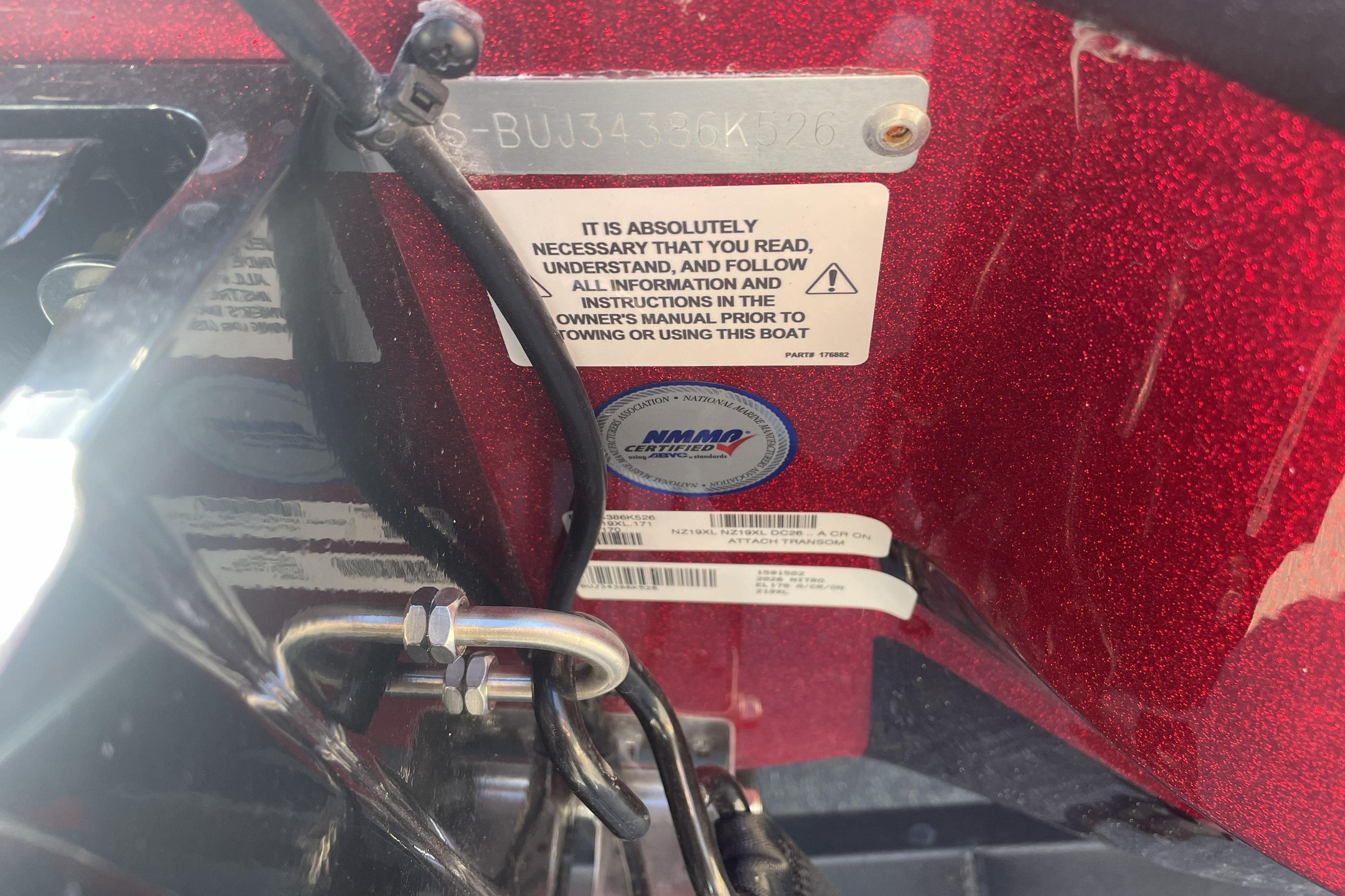 2026 Nitro Z19 XL boat compliance and safety labels on red metallic surface.